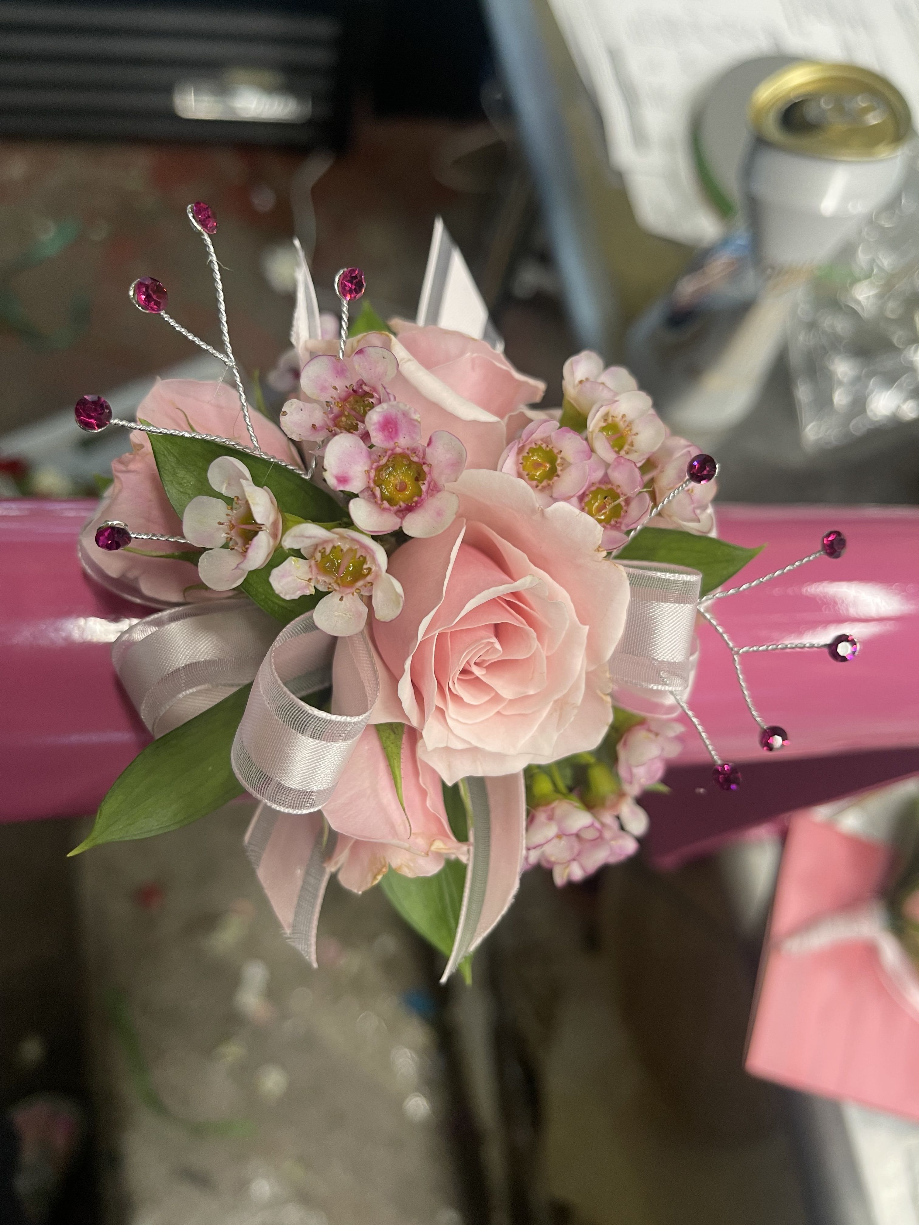 Wristlet Corsage Custom Design - A custom slap-on prom wristlet is the perfect mix of style and comfort for prom/homecoming night. Designed on a flexible slap bracelet base, it’s easy to wear and fits snugly on any wrist. Customers choose their rose color—classic red, blush pink, white, or bold shades like royal blue or lavender—then pair it with coordinating or contrasting ribbons to match their dress or tux. Each piece is hand-designed to be unique, stylish, and dance-floor ready. 