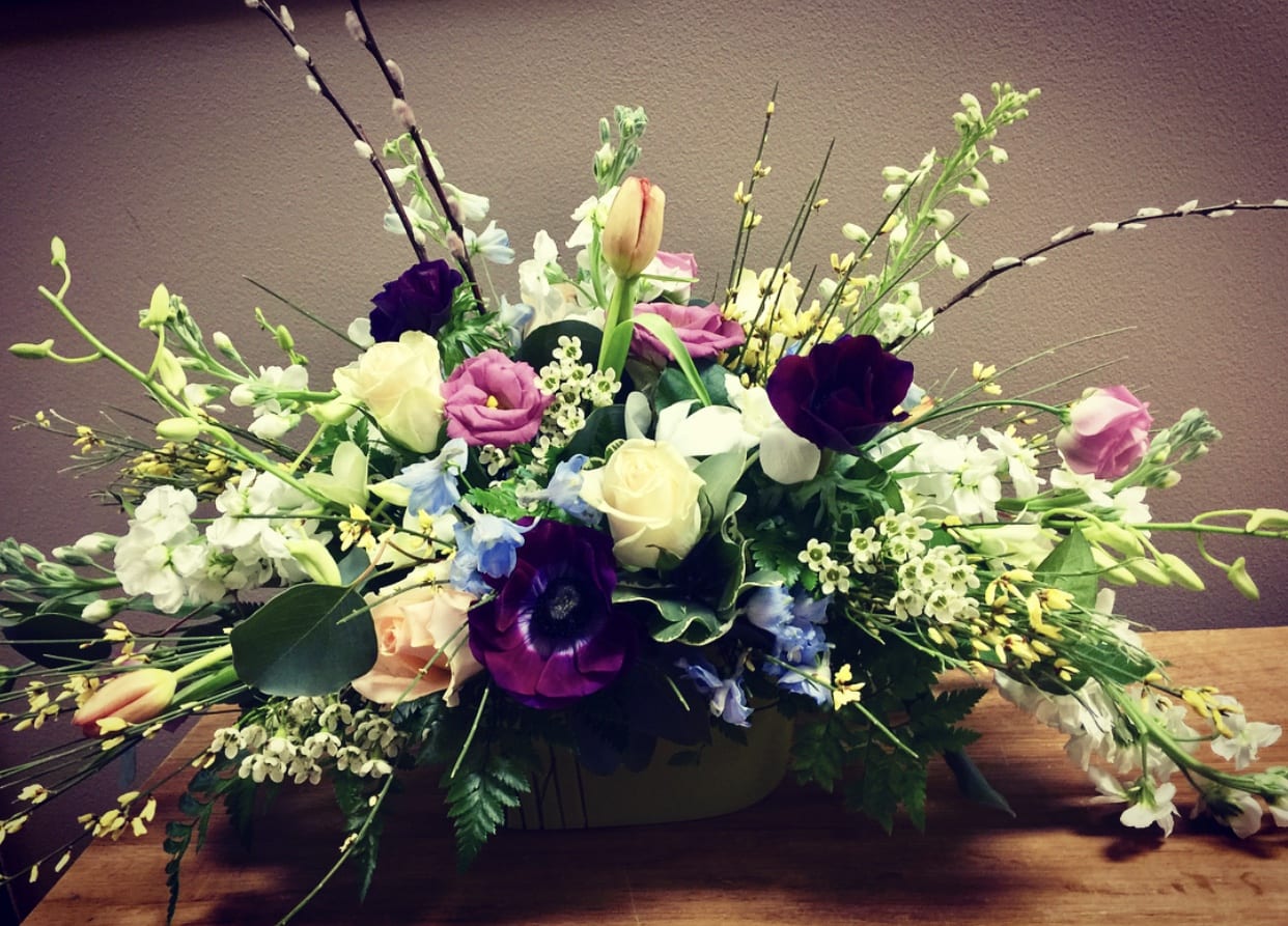 Spring Centerpiece - A low centerpiece that evokes spring time fragrances, textures and blooms. Flower varieties and colors will vary based on our cooler inventory. Perfect for  a dining table or kitchen island.