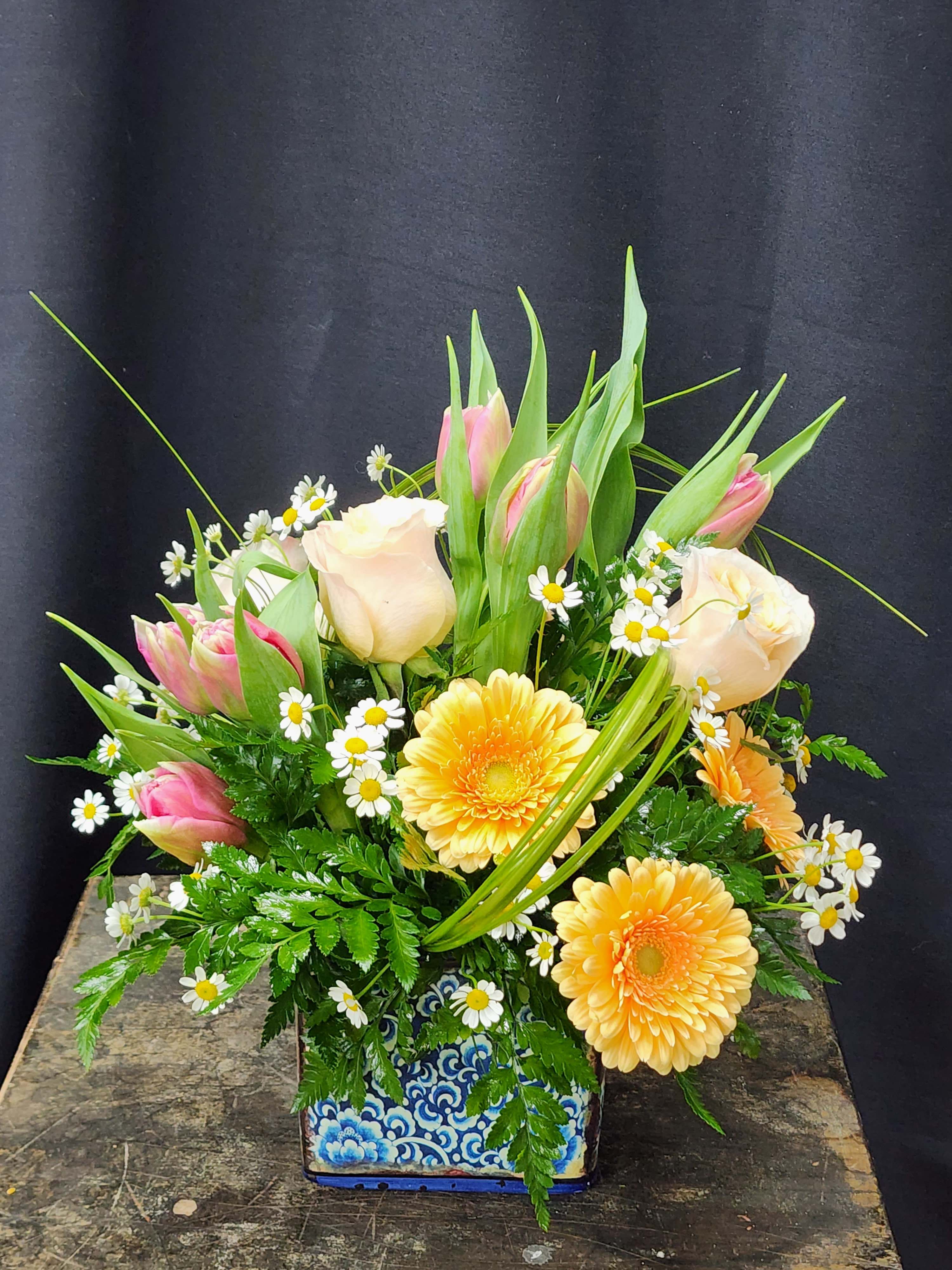 Blue Ceramic Spring Garden - Ceramic container with gorgeous tulips, beautiful gerbera daisies and stunning roses. This sweet and simple bouquet is a great way to surprise her at the office, is perfect for a bedside table, and always brightens anyone's day.