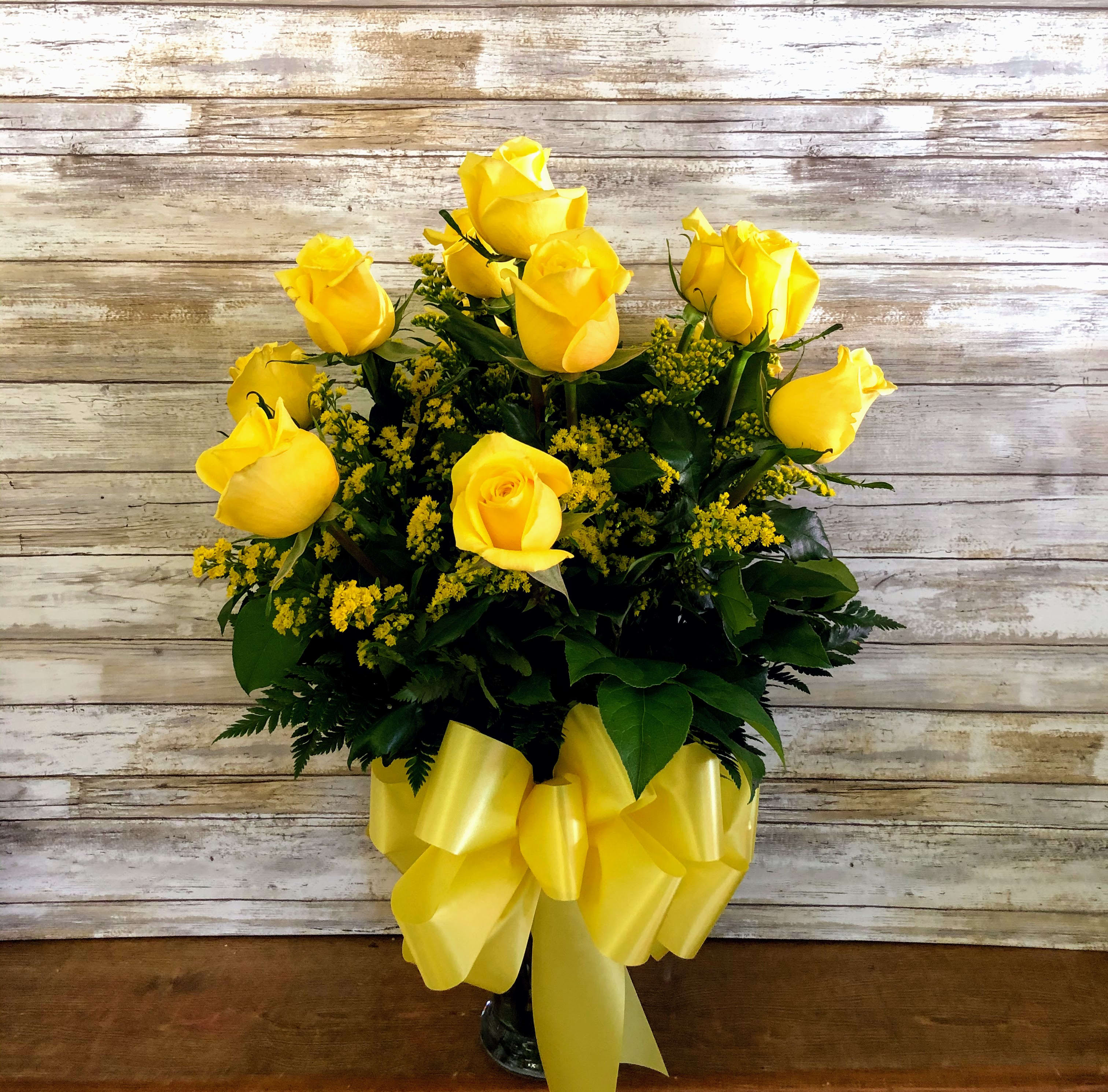 Here Comes The Sun - Yellow roses symbolize friendship, and sending this sunny bouquet of bright yellow flowers is such a beautiful way to celebrate a special bond. Destined to make anyone's day glow, these roses are brilliant!  Glowing yellow roses and solidago mixed with greens are delivered in a clear glass gathering vase. Sunny skies ahead!  Approximately 16" W x 20" H  Orientation: All-Around  As Shown : T70-1A Deluxe : T70-1B Premium : T70-1C