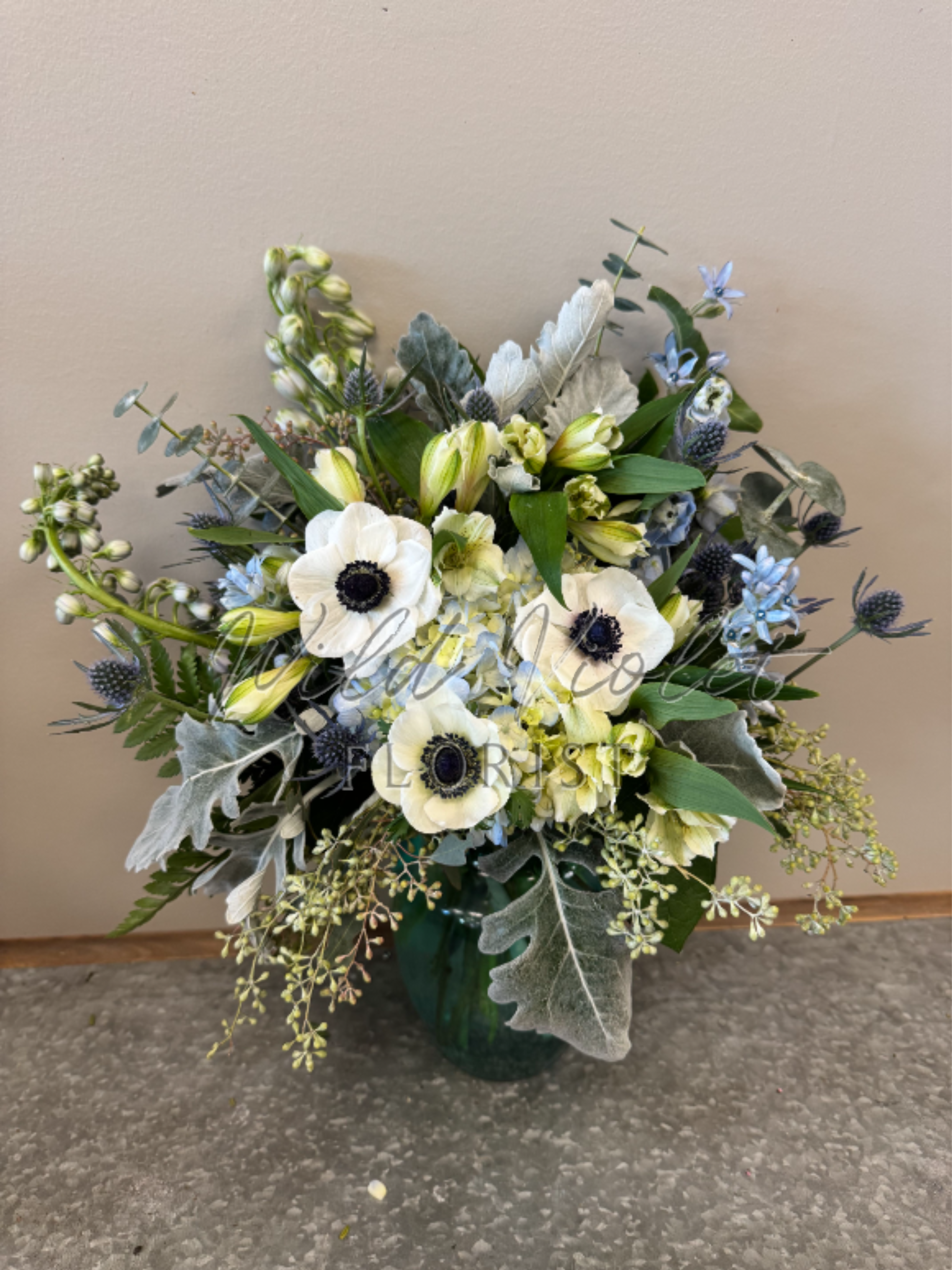 March Aquamarine Bouquet - Birthstone Collection What better way to celebrate your loved one's birthday than with our March Aquamarine Bouquet! Hand-designed with a stunning gathering of light blue and white blooms, lush greenery and silver touches, it’s a thoughtful sentiment filled with the cool and calming beauty of an aquamarine stone.  ATTENTION! If you are ordering this arrangement on a different month other than what it's respected month is, there will be substitutions for certain flowers depending on seasonal availability. We will stay within the same color scheme and design style!  PLEASE NOTE: Florist reserves the right to make modifications to the design based on seasonality and accessibility of blooms and vases. Any modifications made will honor the palette, intent, and feeling of the pictured design. Contact floral designer directly with any specifications or concerns.