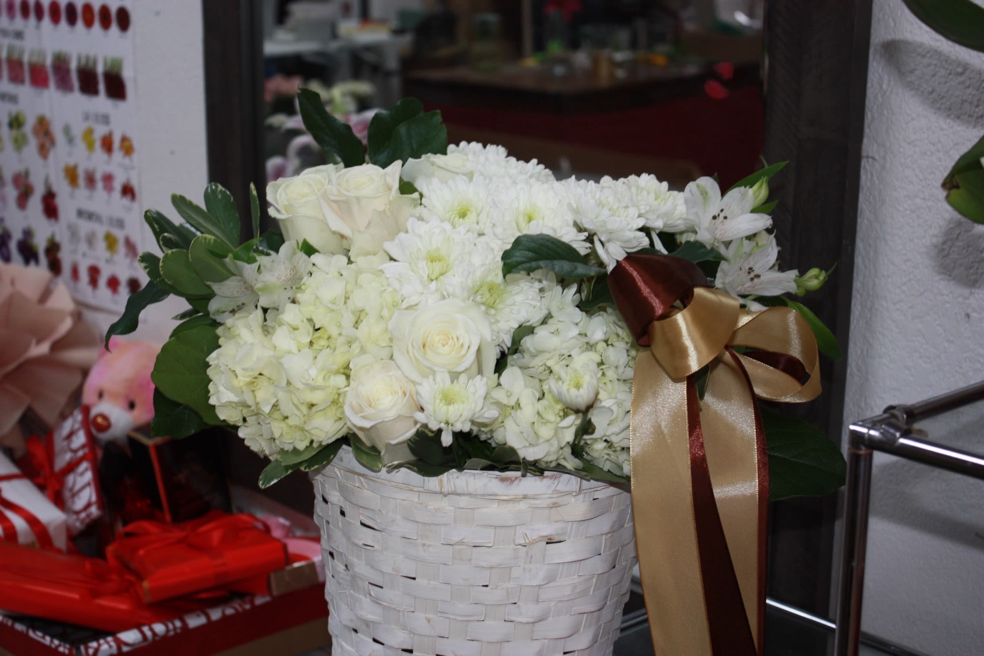 Elegante Basket - White fluffy roses and hydrangeas sit in an all-white basket with a ribbon.  Send this to celebrate the winter season!  Perfect for all  holidays or just because   Approximate Dimensions: 14"D x 14"H