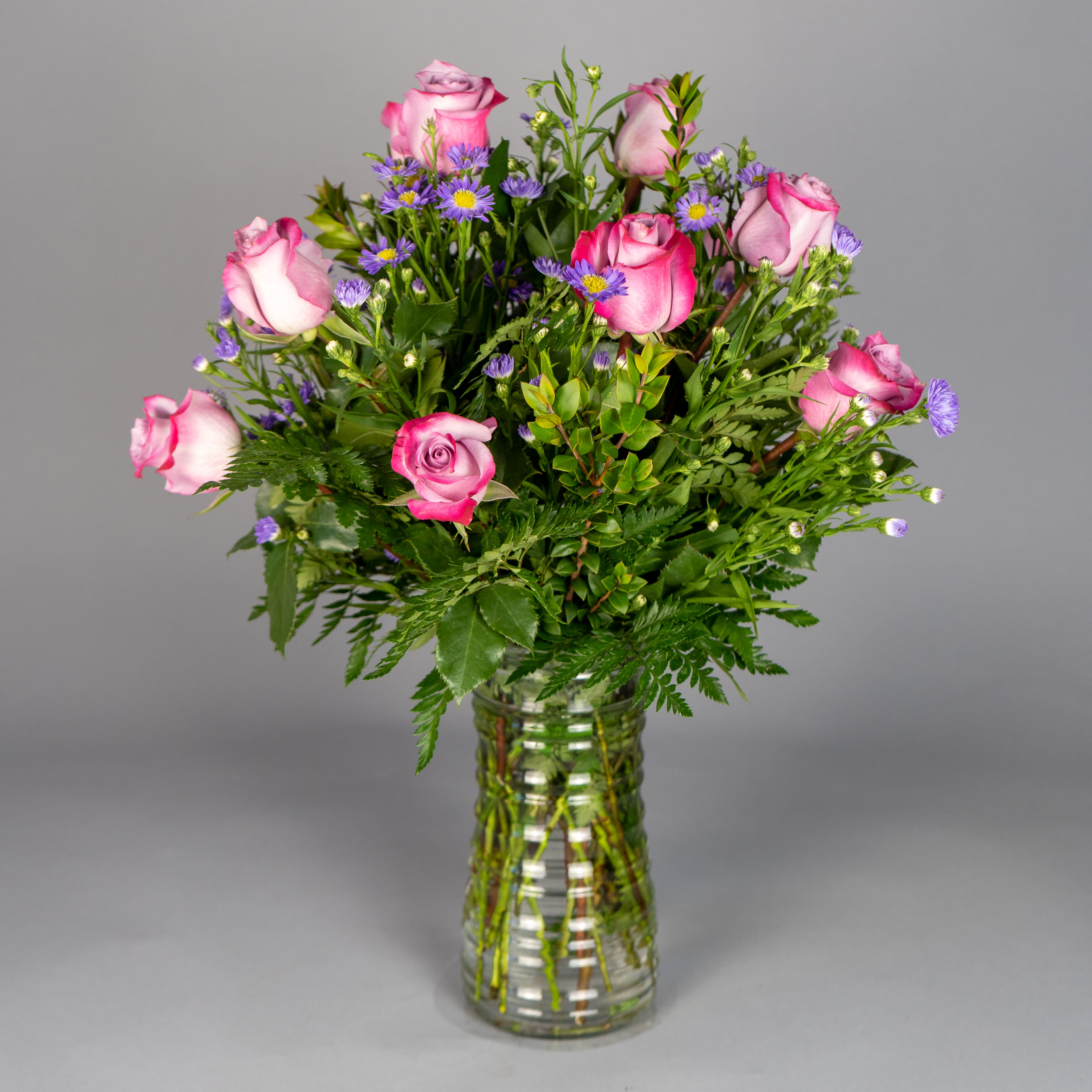 Purple Rose Elegance - The person you care about needs to be treated with respect. Our hand-crafted arrangement of 12 or 24 exquisite long-stem purple roses, grouped in a traditional vase, will add the finishing touch to their special day.