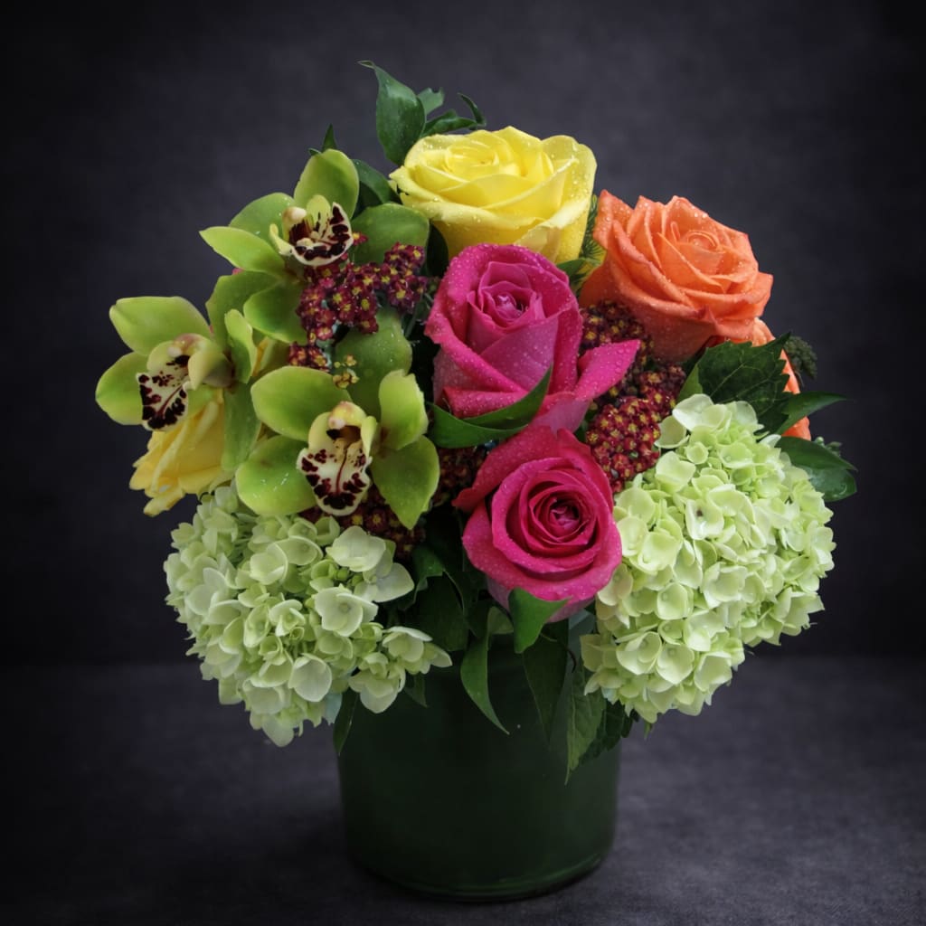 spring occasion - A gorgeous, bright and modern arrangement of roses, hydrangea, cymbidium orchid and greens styled in a clear glass vase. Bringing cheer to any day.