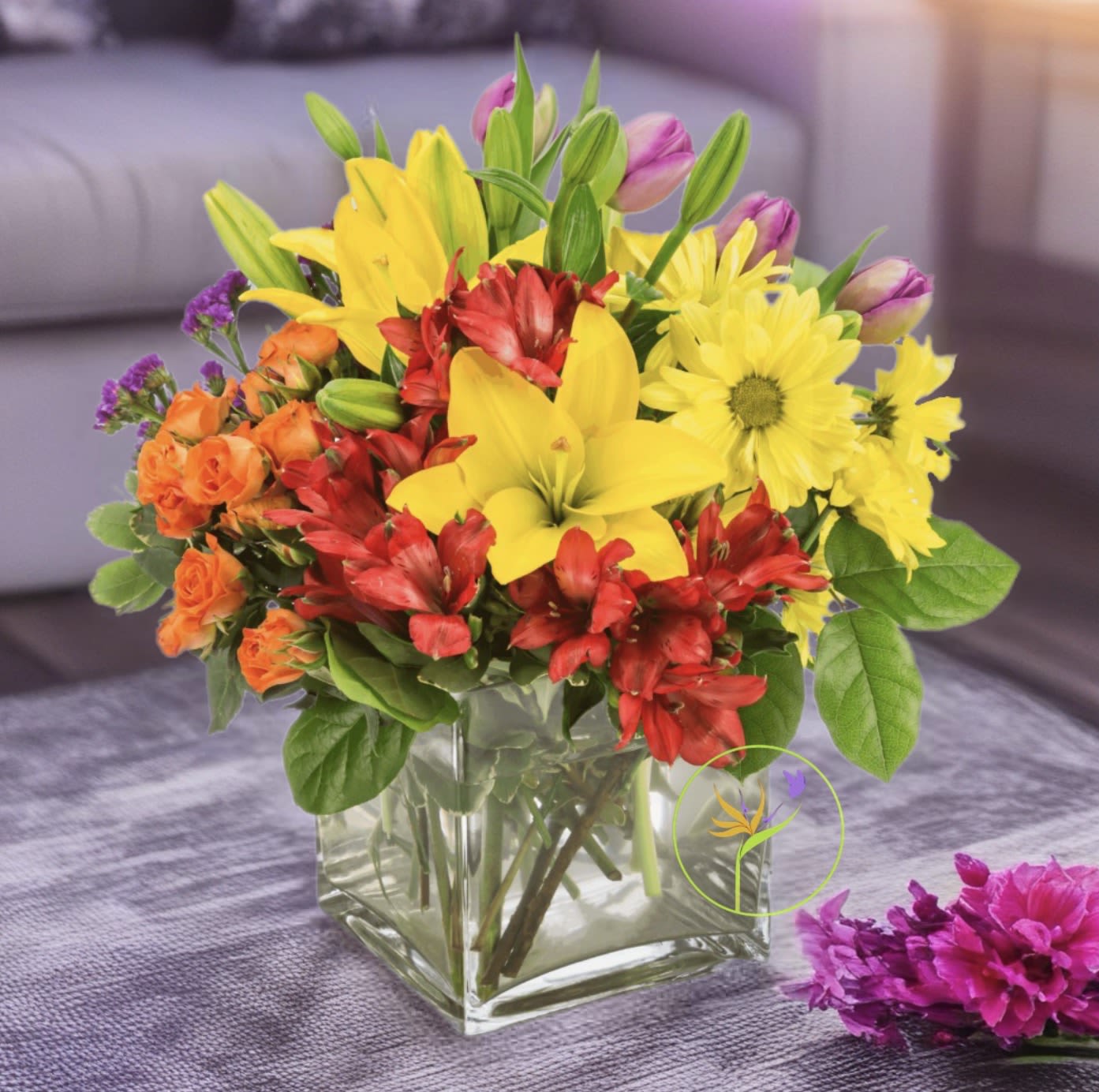Juicy. BN™ * - Juicy by BloomNation™, packs a color punch! Featuring over 6 different flowers and greens, all in different colors, this arrangement is a great option for sending to co-workers, friends, or clients. Make a brightly colored splash.  NOTE: Our flowers and greens are a gift from nature. It’s shade and depth might vary, design and aesthetic remains the same.  In support of our efforts to aide in the preservation of our planet, PJf uses Fair Trade flowers, Plants, Upcycled and Recycled containers.