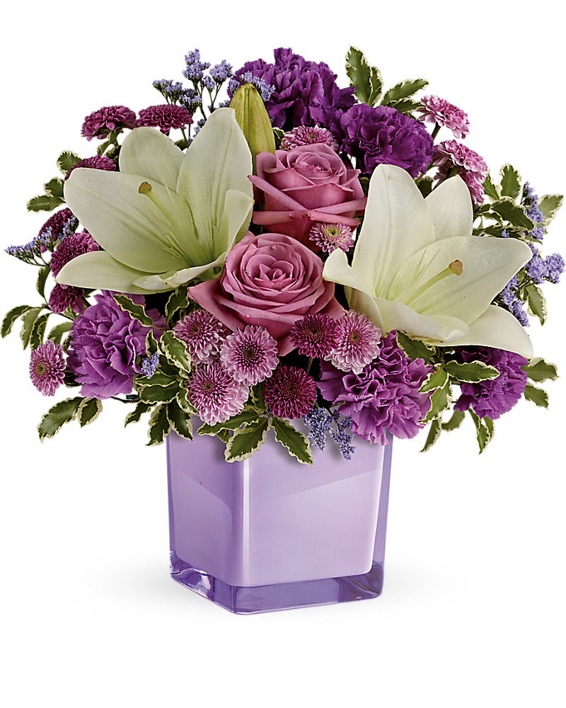 Pleasing Purple Bouquet - These luxurious lavender roses and crisp white lilies are poised to please! Perfectly presented in a stylish cube vase, it's an any-occasion surprise they'll never forget! Lavender roses, white asiatic lilies, purple carnations, lavender carnations, purple button spray chrysanthemums and lavender button spray chrysanthemums are arranged with lavender limonium and pitta negra. Delivered in a 4x4" glass cube - arrangement measures approx. 11.5x11" for Standard size, 12.5x12" for Deluxe, and 13x13.5" for Premium.