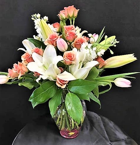 Blushing Sunset - This beautiful arrangement consist of lilies, spray roses, tulips and other blooms. 