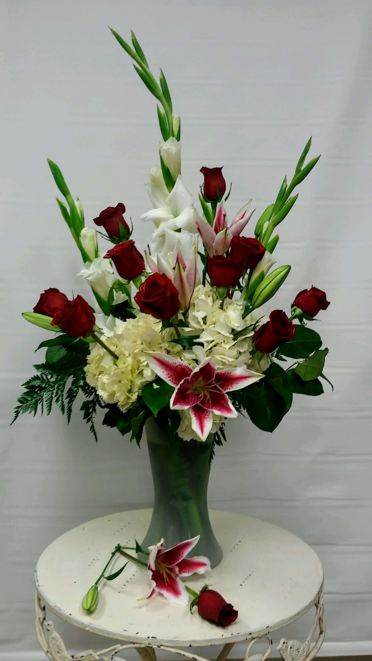 Splendor - A splendid bouquet made up of our beautiful red roses, star fighter lilies, hydrangeas and gladiolus gathered in a glass vase. 