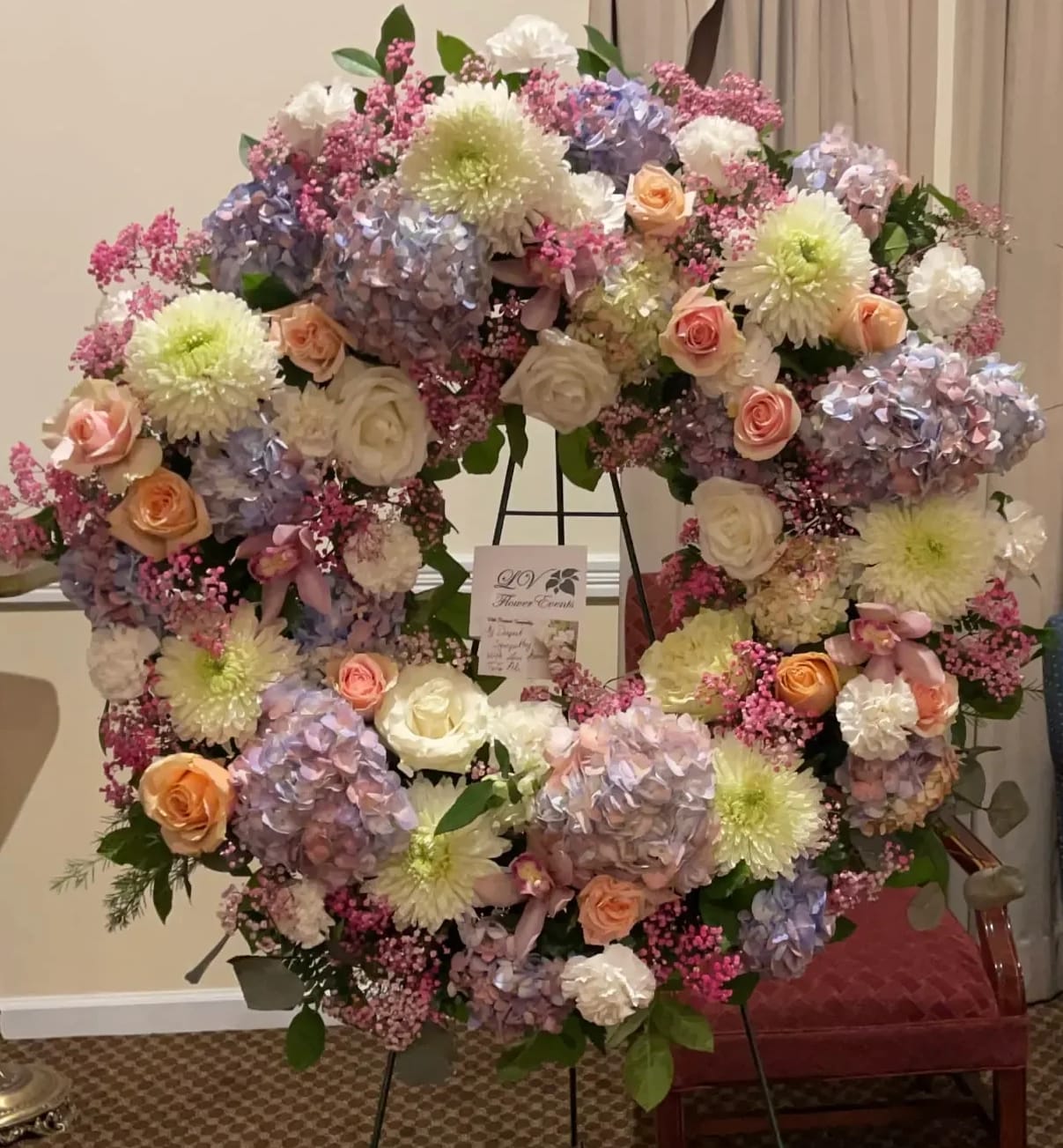 Pastel Sympathy Wreath - A sympathy wreath filled with unique flowers including baby breaths, carnation, roses, hydrangea, and chrysanthemums.
