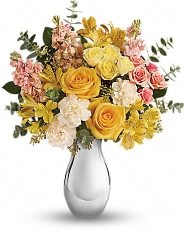 Soft Reflections Bouquet - Soft, sunshiny blooms and a sparkling silver vase combine to striking effect in this magnificent bouquet. Its yellow and peach roses and keepsake vase are sure to make them smile, no matter the occasion! This soft mix of yellow roses, light yellow spray roses, peach spray roses, yellow alstroemeria, crÃ¨me carnations and peach stock is accented with spiral and seeded eucalyptus. Delivered in a Silver Reflections vase. 