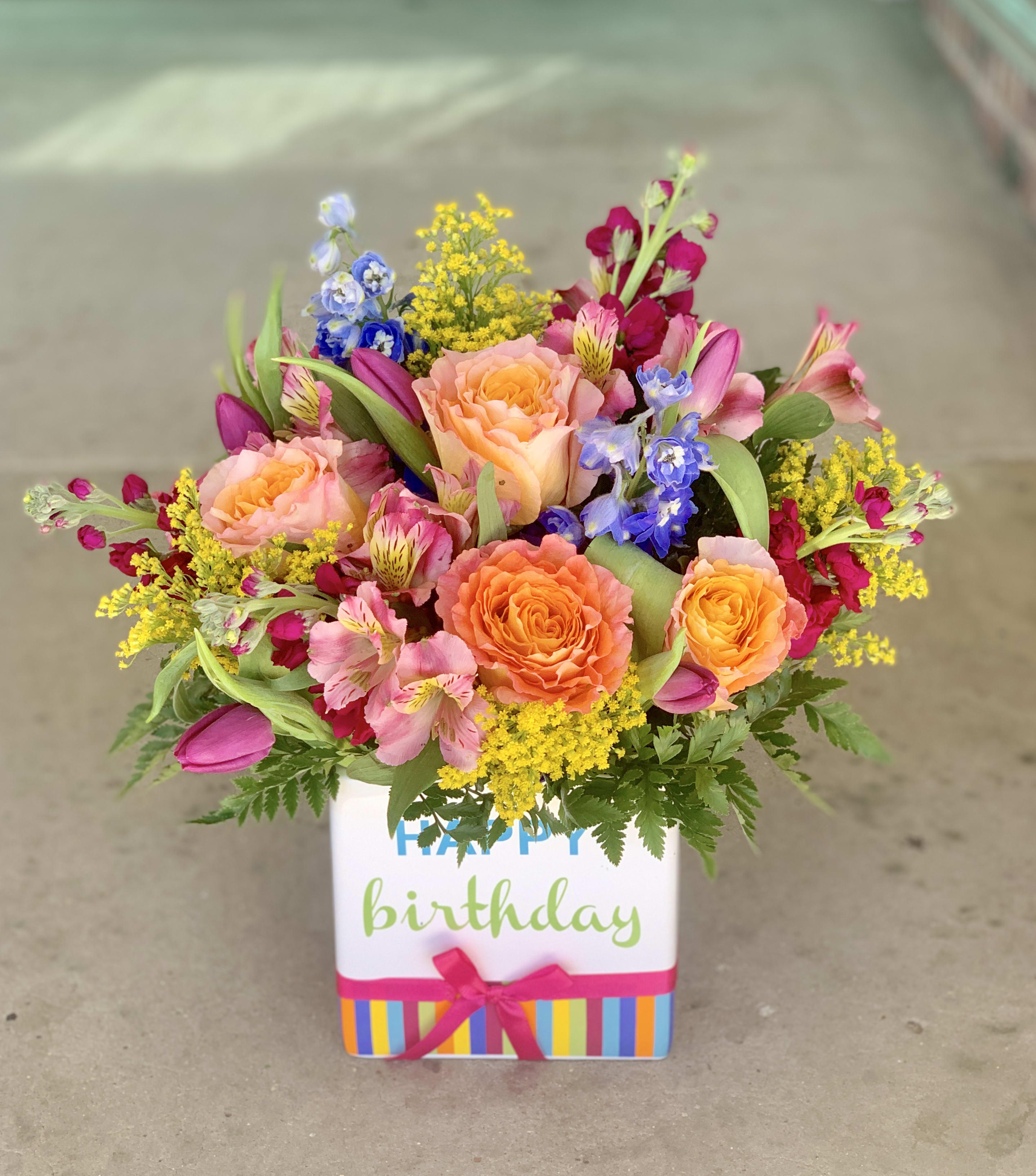Marilyn Monrose - These beautiful birthday blooms are sure to make your special someone smile! Vibrant and bright blooms arranged in a keepsake Happy Birthday container!