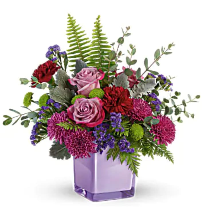 Purple Serenity Bouquet - Soft and serene, this rich bouquet of lavender roses and moody maroon blooms is a touching gift any day of the week, especially presented in this stunning keepsake amethyst-colored cube! Lavender roses, maroon carnations, purple cushion spray chrysanthemums, green button spray chrysanthemums, and purple sinuata statice are accented with sword fern, leatherleaf fern, dusty miller, and parvifolia eucalyptus. Delivered in an Amethyst Color Splash Cube.   Orientation : All-Around  All prices in USD ($)  Standard  TEV59-6A  Deluxe  TEV59-6B  Premium  TEV59-6C