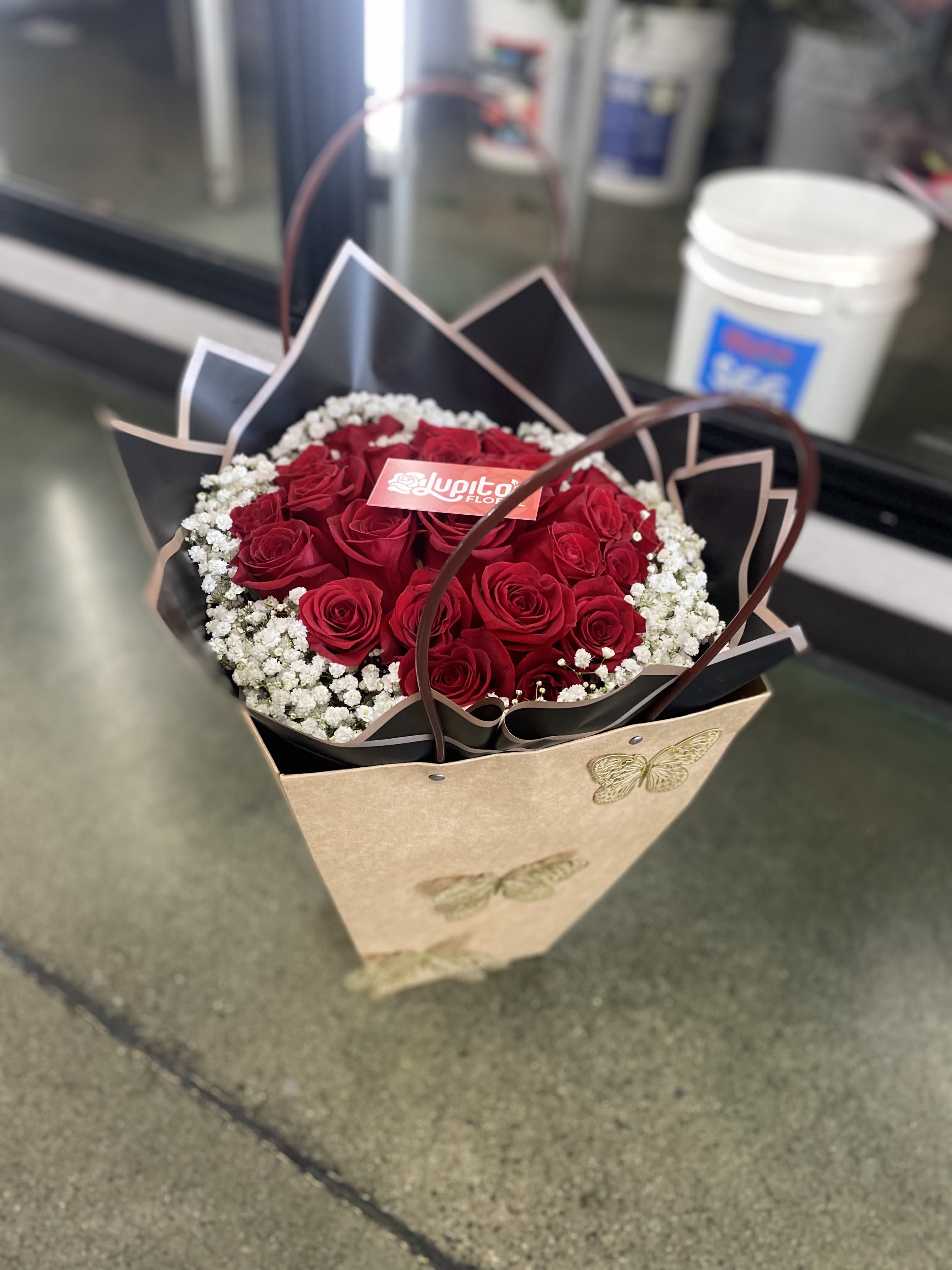 Small Buchón in a Bag - This small buchón consists of 24 Roses, babies breath, and a small glass vase inside of our waterproof bags.  You may request change of color during checkout.