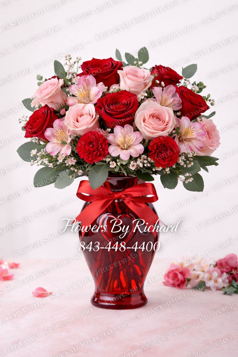 Ruby Blush Romance - Rich red roses and carnations are beautifully paired with soft blush pink roses and delicate accent blooms in a striking red glass vase finished with a coordinating ribbon. Lush, full, and undeniably romantic, this arrangement is perfect for anniversaries, romantic surprises, or celebrating someone special in a bold and elegant way. Hand-delivered throughout Myrtle Beach and surrounding areas, with substitutions made as needed to ensure the freshest blooms.