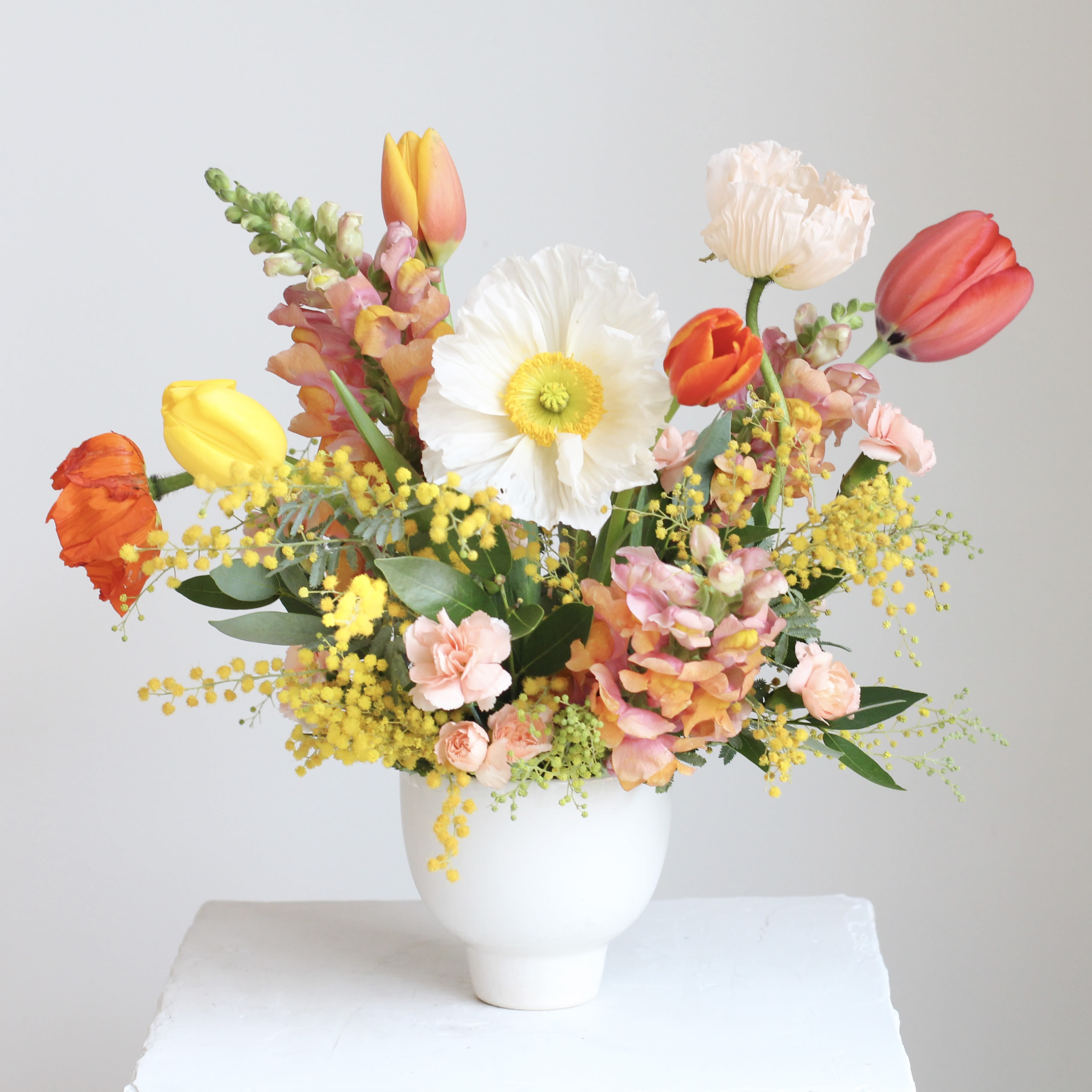 The Golden - Celebrate the ever changing beauty of our beloved hometown with "The Golden", an accent table arrangement designed to brighten your space! This rotating selection of seasonal flowers features stunning blooms in shades of gold, pink, orange, and yellow, bringing warmth and joy to any room or occasion.  Delivery Policy: At Middlemist, we aim to make every delivery seamless and delightful. It is the sender’s responsibility to ensure the recipient is available to accept delivery between 3–5pm on the scheduled date and that the delivery address is accurate. We will send a text notification to the recipient on the day of delivery. If no one is available to receive the order, it will be returned to the shop and may be picked up or redelivered for an additional delivery fee. If a recipient requests the order be left unattended, we cannot guarantee the condition of the flowers or plants, and no refunds will be issued once an order is left outside.