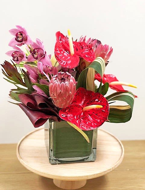 SALE! Hawaiian Rhapsody SAVE $70 - Celebrate love island-style with our Hawaiian Valentine Bouquet, a tasteful arrangement of exotic tropical blooms that will leave a lasting impression.  Features stunning orchids, protea, and other captivating tropical flowers, showcasing the natural beauty of Hawaii.  Designed with care to create a vibrant and intriguing display, perfect for Valentine’s Day.  A unique and heartfelt gift, ideal for those who appreciate the exotic and unforgettable.  This Hawaiian-inspired Valentine’s option brings a touch of paradise to your loved one, making the day extra special. Perfect for expressing aloha and love! ️