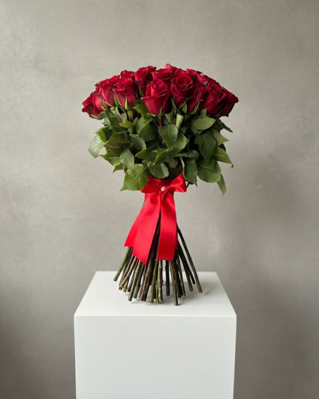 50 Red Roses – Classic Hand-Tied Bouquet - A romantic and elegant design that lets the flowers take center stage. This bouquet features 50 premium red roses, expertly arranged in a classic hand-tied style, with no paper wrapping and finished with a traditional red ribbon, highlighting the natural beauty of the stems and blooms. Perfect for Valentine’s Day, anniversaries, proposals, or expressing love in a timeless and sophisticated way.  Note: Rose shades and stem length may vary slightly depending on seasonal availability.
