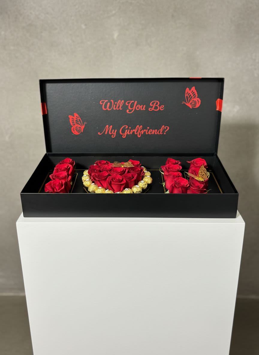 Will You Be My Girlfriend? Luxury Gift Box - Make the moment unforgettable with our romantic floral gift box designed to melt hearts. This elegant arrangement features fresh red roses beautifully styled to spell out I ️ U, surrounded by Ferrero Rocher chocolates for a sweet touch. Delicate golden butterfly accents complete the design, adding charm and sophistication.  Perfect for proposals, anniversaries, or simply expressing your love in the most thoughtful way, this luxury box is more than a gift—it’s a memory that will last forever.