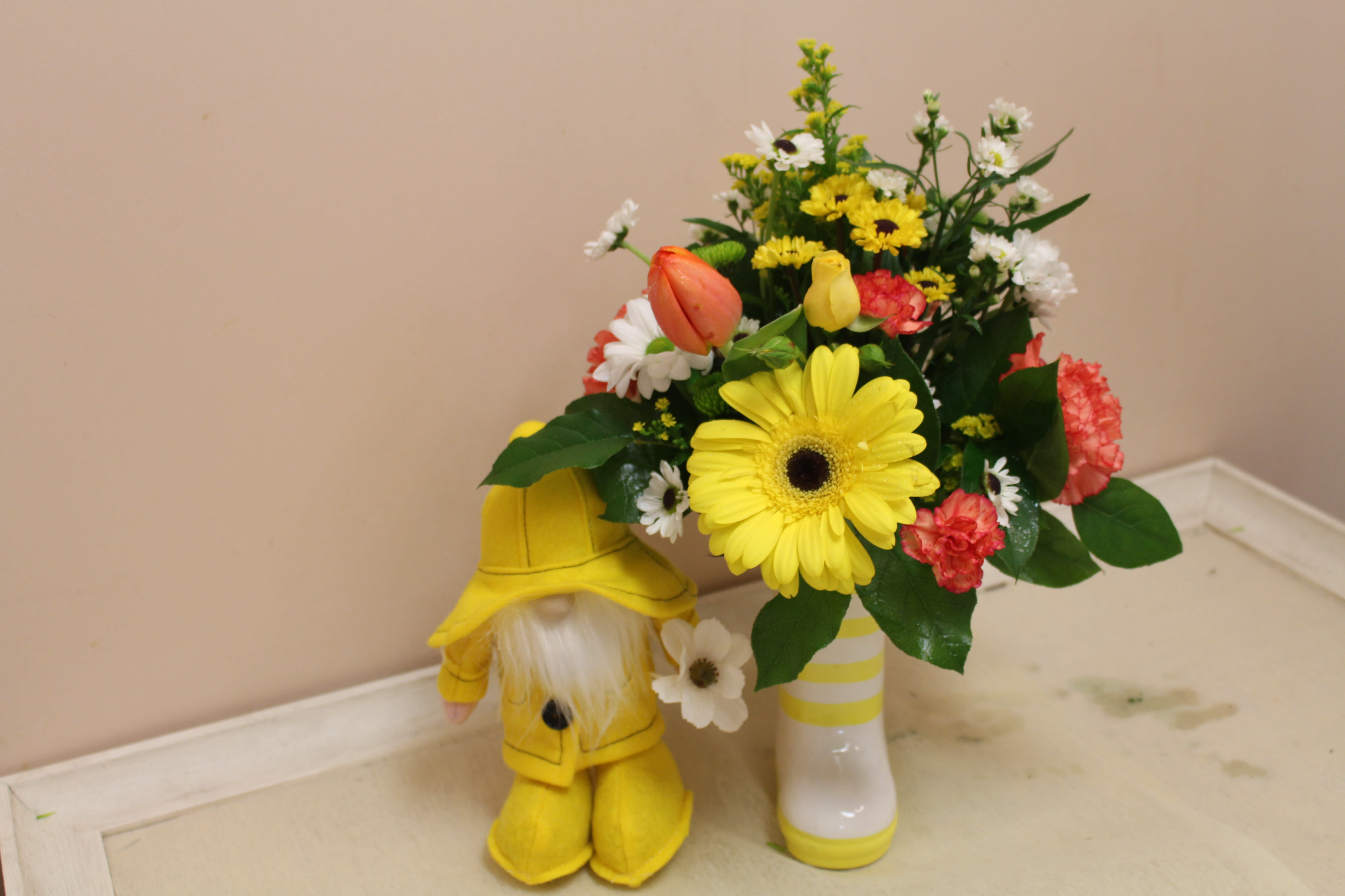 rain showers bring spring flowers mini - How cute is this... Spring days are rainy for sure.  This adorable gnome is stuck in the rain with his slicker and yellow boots.  Enjoy this spring arrangement all in a rainboot!!! too cute