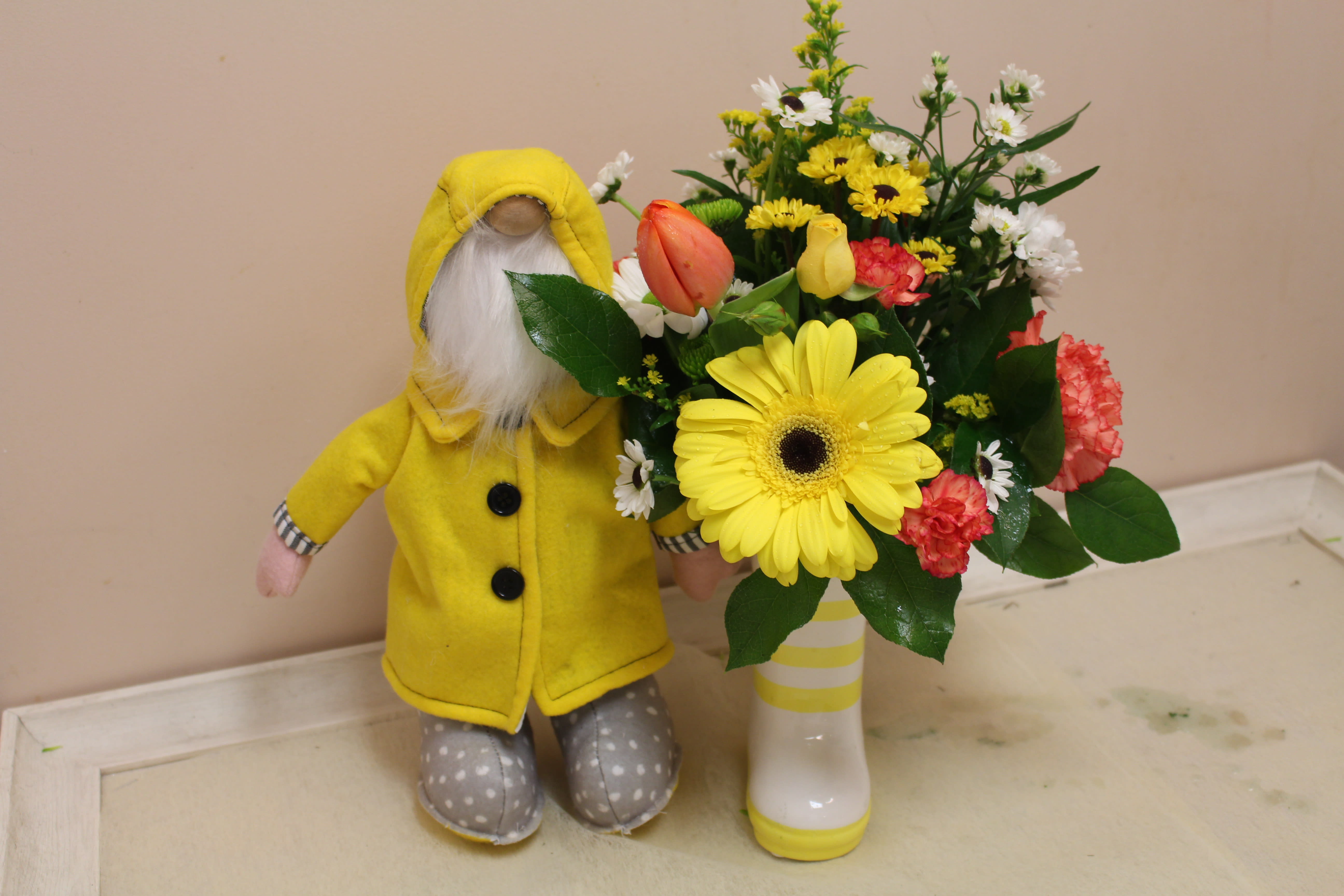 London Fog  - How cute is this... Spring days are rainy for sure.  This adorable gnome is stuck in the rain with his slicker and grey polka dot boots.  Enjoy this spring arrangement all in a rainboot!!! too cute