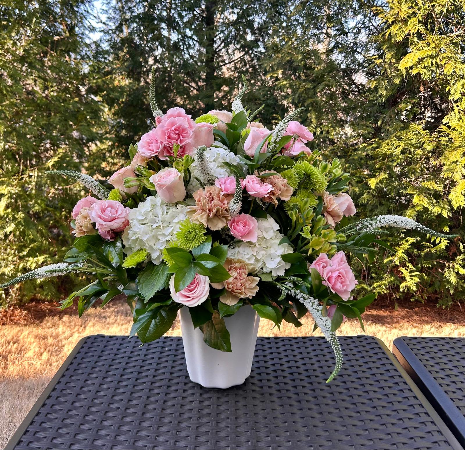 Cameron  - This arrangement is a gentle caress for the eyes and the heart. Created with delicate light pink roses, elegant white flowers, and lush green foliage that adds freshness and texture, it's the perfect choice for celebrating life's sweetest to support at a service or funeral home.   Presented: Vessel in Neutral White  Place your Order Online Monday to Saturday before 1:00 p.m. (E.T.) for same-day delivery. “Orders received after hours will be delivered the next business day”. Check our coverage area.  Occasionally, flowers and/or containers are substituted due to weather, seasonality, and market conditions, which may affect availability. If this is the case with the gift you’ve selected, we will ensure that your arrangement's style, theme, and color scheme are preserved and will only substitute items of equal value or higher value.  CARE INSTRUCTIONS Keep the flower arrangement hydrated with natural water and change the water every two days. Do not spray any cleaning product on the flower arrangement. Do not place heavy objects directly on the flower arrangement. Keep flower arrangements out of direct sunlight and extreme heat.