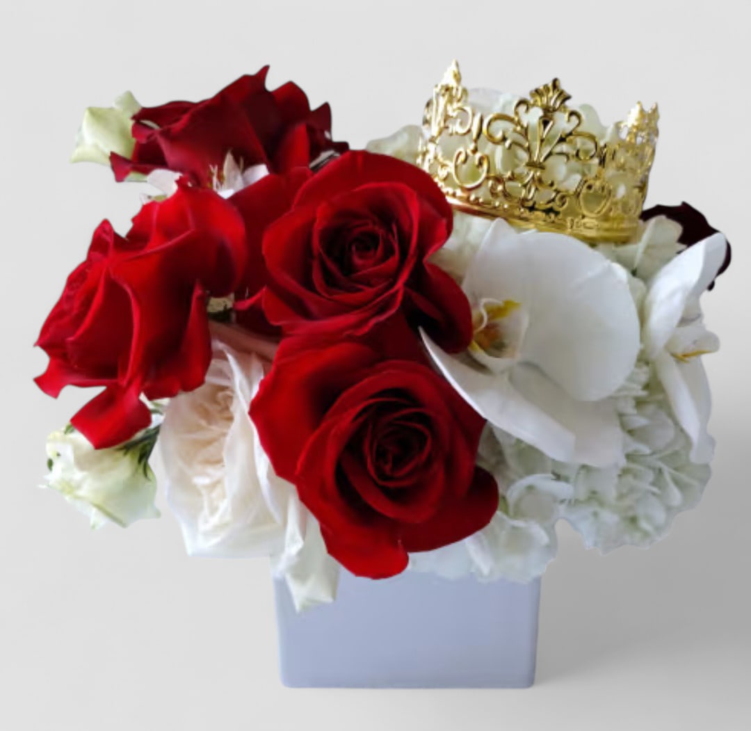 Royal Red Rose Crown Bouquet - Luxury Romance Collection - Please call first for availability. Please allow 48 hour notice. Make them feel like royalty with our Royal Red Rose Crown Bouquet, a luxurious arrangement of romantic red roses, elegant white orchids, and soft hydrangeas, all accented with a shimmering gold crown. Designed in a modern white vase, this show-stopping bouquet is perfect for anniversaries, Valentine's Day, or any special moment where only the most stunning flowers will do.  Each bouquet is handcrafted with care, ensuring every design is unique and breathtaking. This best seller brings together the timeless beauty of roses with the elegance of orchids and the charm of luxury accents.  We proudly offer local South Jersey flower delivery to Haddonfield, Haddon Township, Cherry Hill, Moorestown, Mount Laurel, and surrounding towns.   Send a message of romance, elegance, and sophistication today with this unforgettable red rose arrangement. 