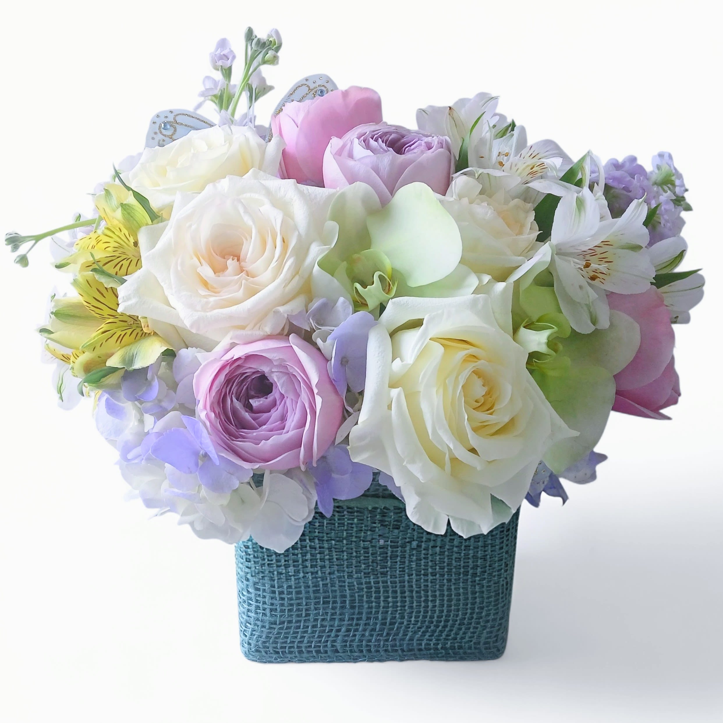 Blue Hydrangea Designer's Choice - Beautiful blue and white roses hydrangeas and more arranged in a pretty modern glass vase wrapped in lovely blue jute ribbon adorned with a sweet spring blue butterfly. Perfect for every reason to show them how much you care. Send happiness.