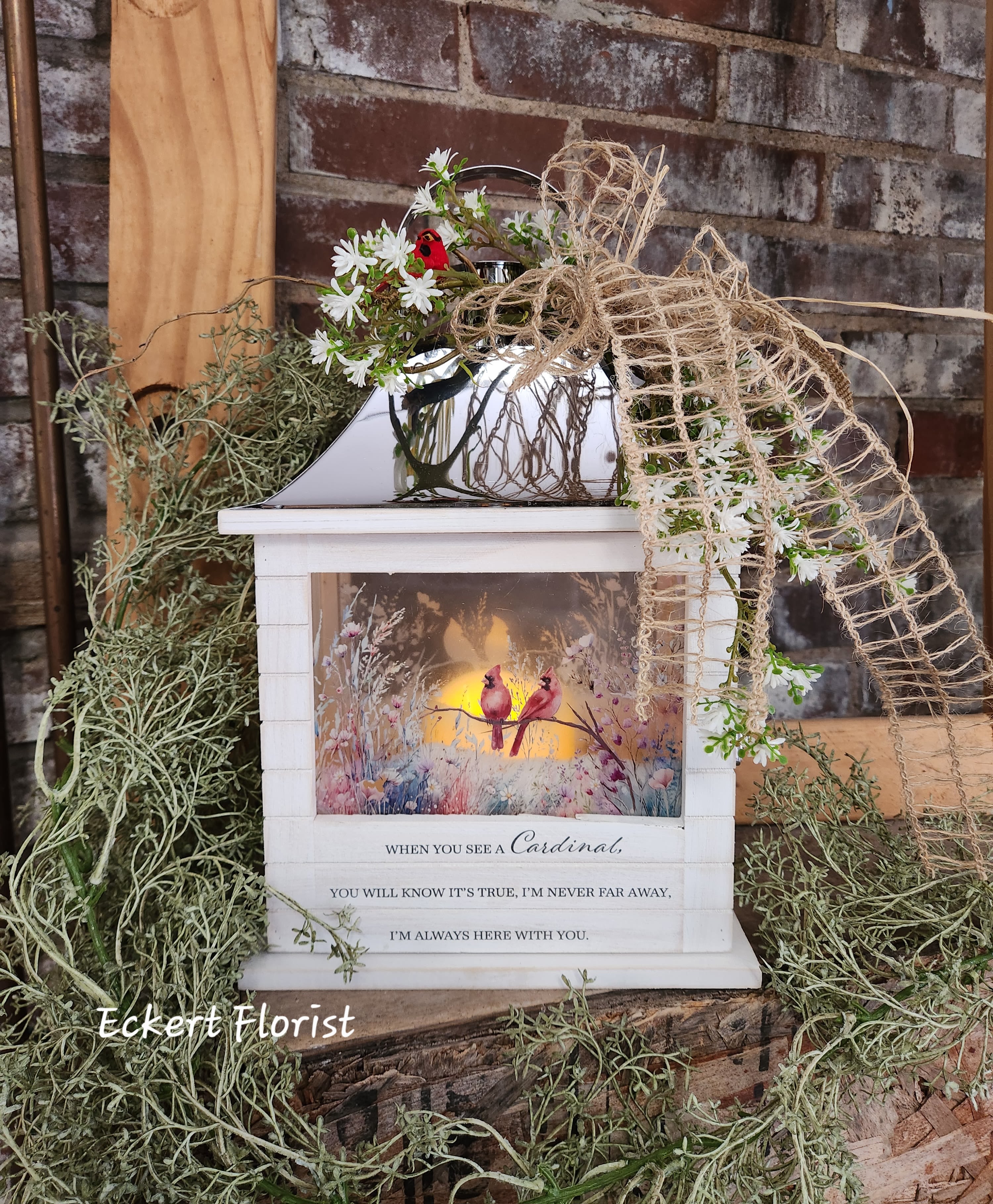 Eckert Florist's Cardinal Wooden Slat Lantern *Our Local Delivery Only - This Wooden Slat lantern is made with quality wood with a stainless steel finish top. It comes inscribed with a sentimental quote amid beautiful artwork on all four sides and a charming flame-less LED candle. Suitable for hanging or use as a freestanding item. 3 AAA batteries included. Lantern Reads: When you see a cardinal, you will know it's true, I'm never far away, I'm always here with you. W: 8.75" x H: 12.5" x D: 5.25"