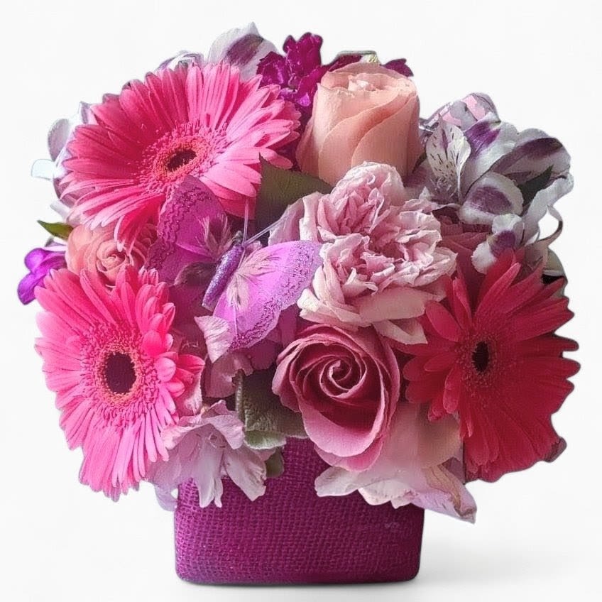 Sending Hugs Bouquet Designer's Choice - Beautiful and filled with pink and white roses orchids and more arranged in a modern glass vase wrapped in pretty pink jute ribbon. Perfect to send today to make their day. Always made extra special and unique each time. Send happiness.