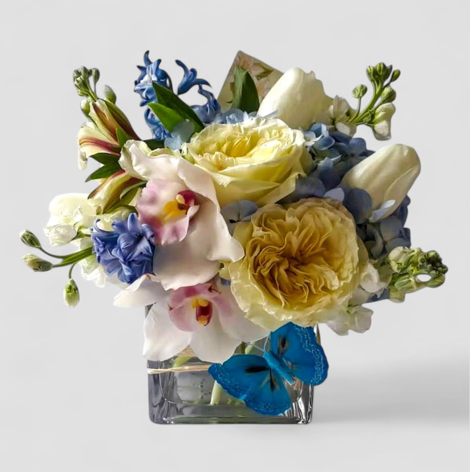White Roses And Orchids Beauty Designer's Choice - Perfect for every occasion. Send this beauty today to show them how much you care with it's beautiful mixed white flowers of that day arranged in a modern glass cube vase. All fresh flower arrangements that leave my studio are works of art, made with lots of care. Please visit my beautiful gallery to see my most recent designs that I have created for my online customers. Send them happiness. Send them a special bouquet to make them smile.