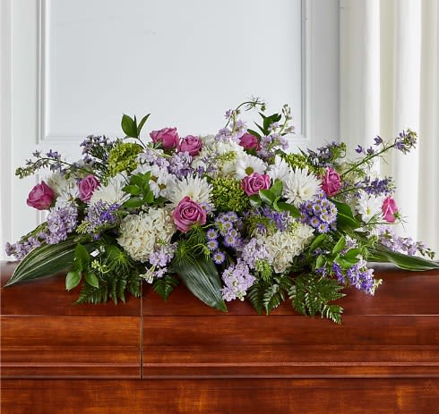 Meadows of Serenity Casket Spray - The Meadows of Serenity Casket Spray is designed using the calming aura of lavender hued florals, arranged by a local florist to adorn a casket with grace.