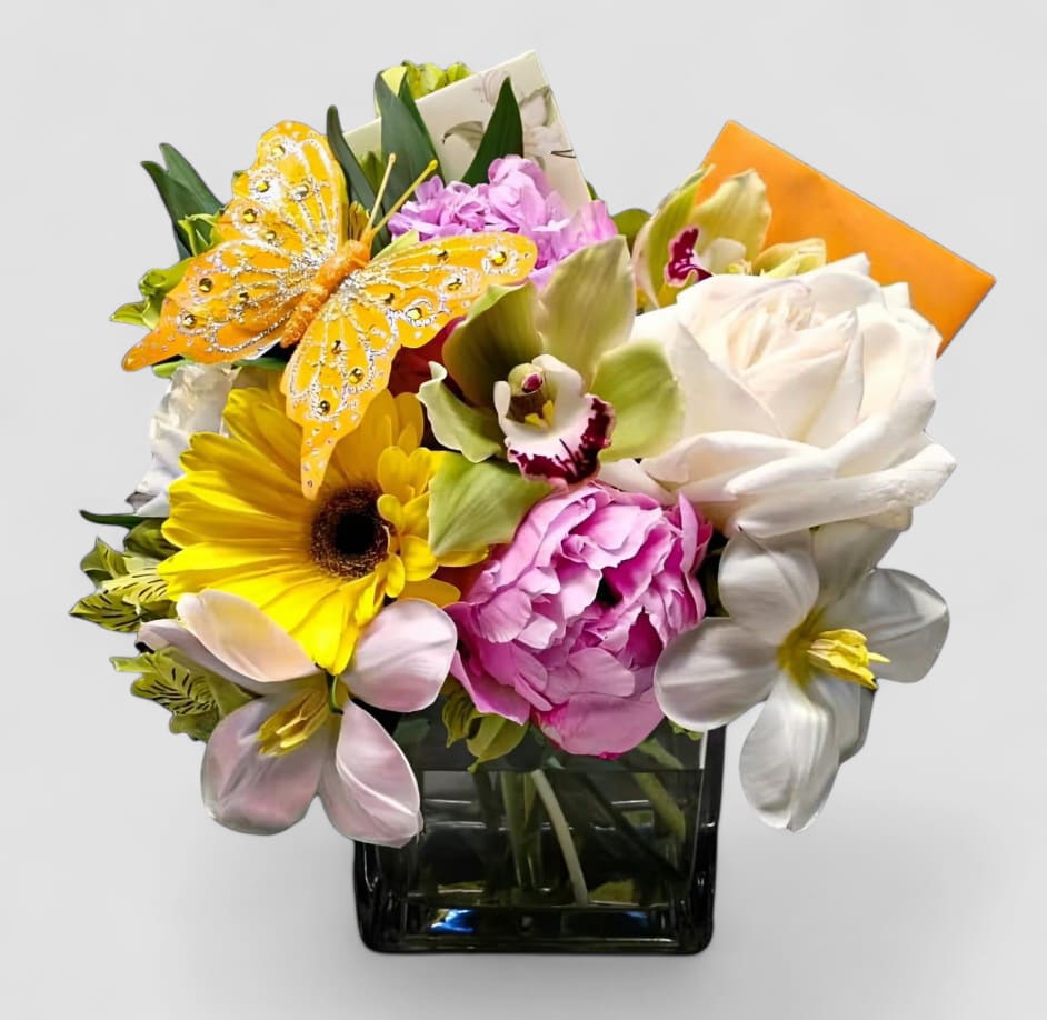 Happy Birthday Sweet Friend Blossoms Designer's Choice - Designer's choice; made beautifully from my cheerful blossom selection of the day roses orchids daisies and so much more arranged in a modern glass cube style vase adorned with a sparkly butterfly. So pretty and perfect to send today to with them a happy birthday. Always made unique and extra special each and every time. Send them happiness.