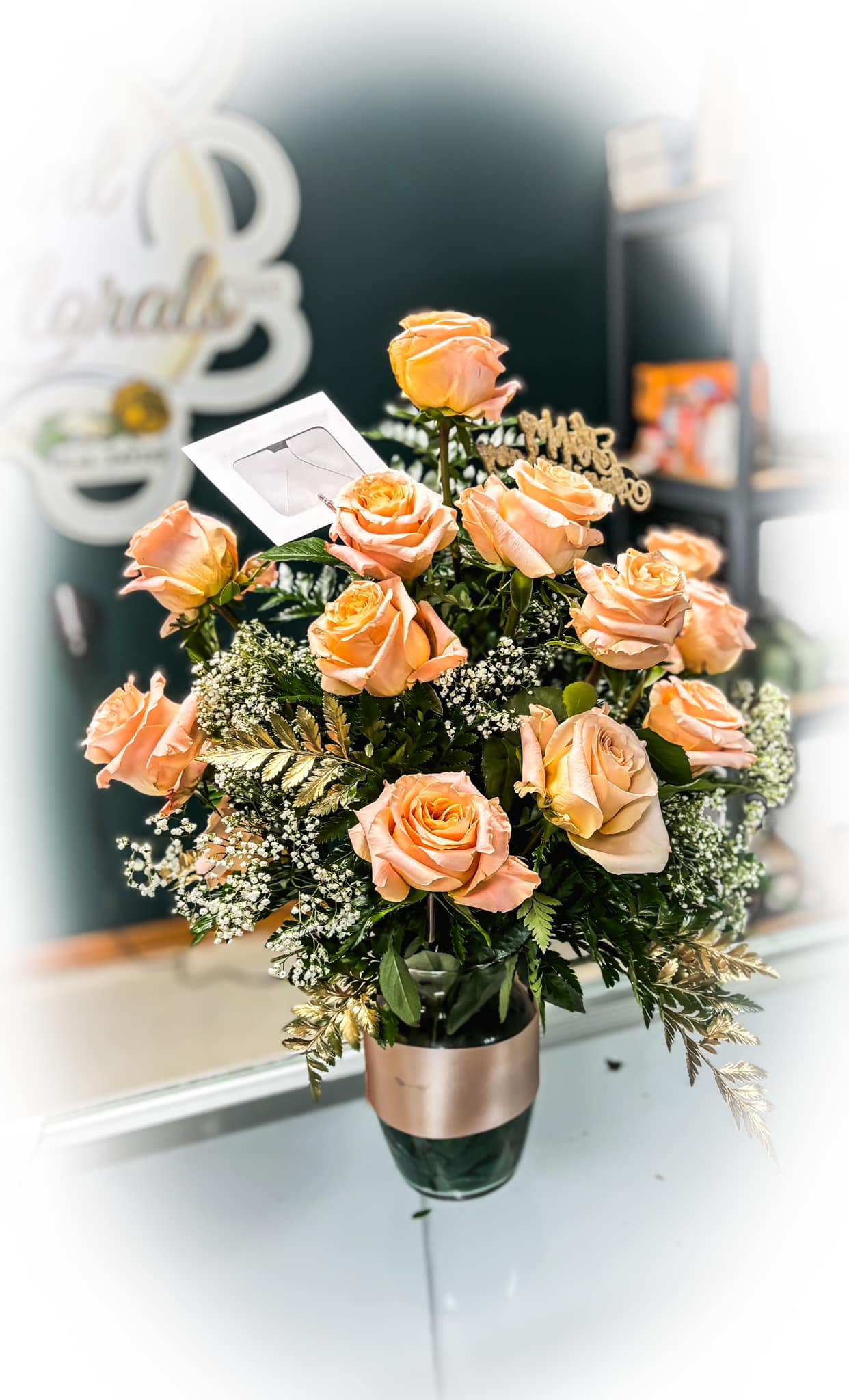 The Sha'Lon Rose Arrangement - Introducing the Sha‘Lon Arrangement. This stunning arrangement features 12 natural fresh peach colored roses, carefully selected and arranged by our expert florists. Give us a call at your friendly local floral shop to order yours today! 