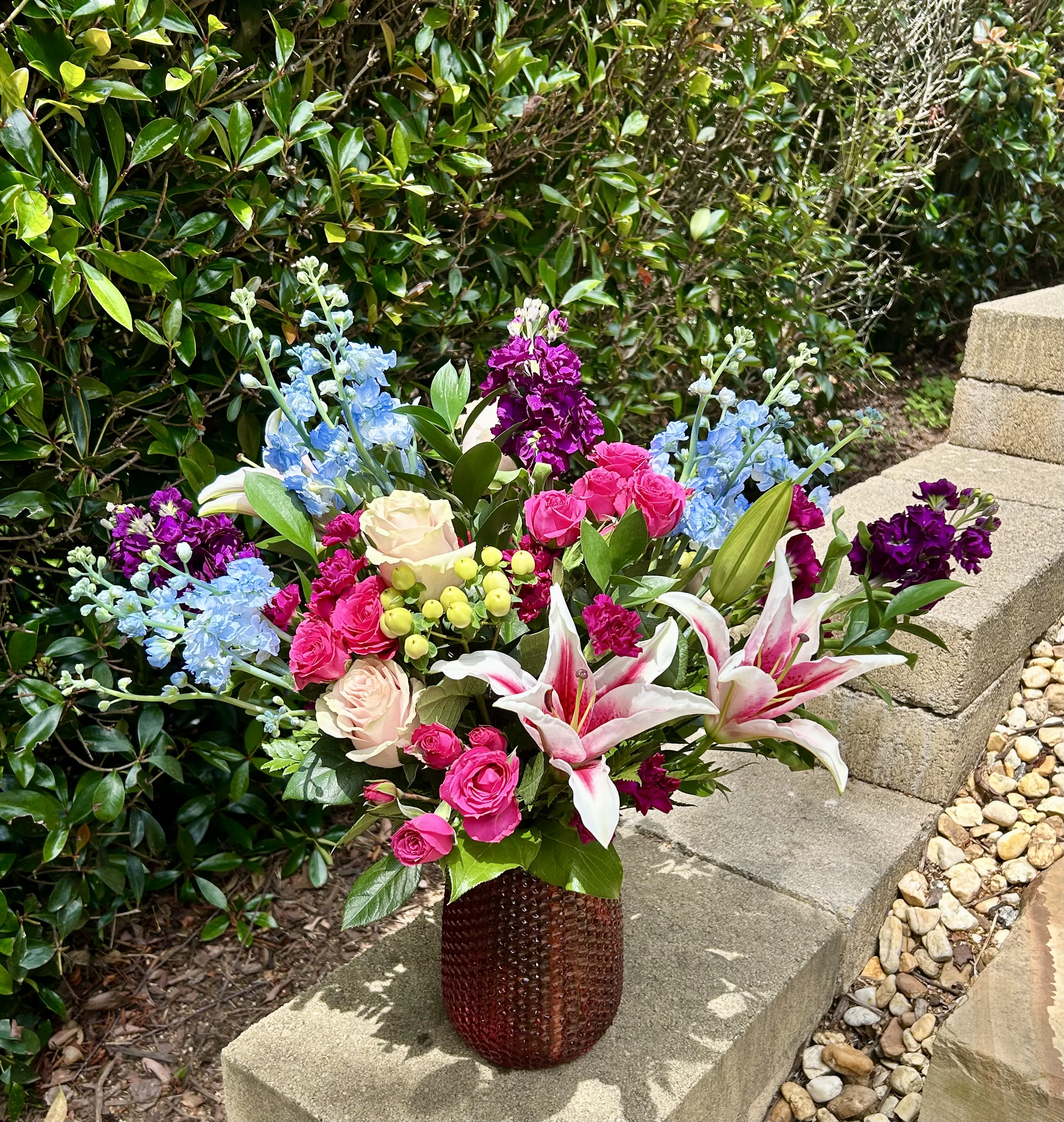 Royal Whisper - A captivating bouquet that speaks in tones of elegance and allure. With rich purples, vivid blues, bold hot pinks, and pure pink roses, Royal Whisper is perfect for marking special moments.