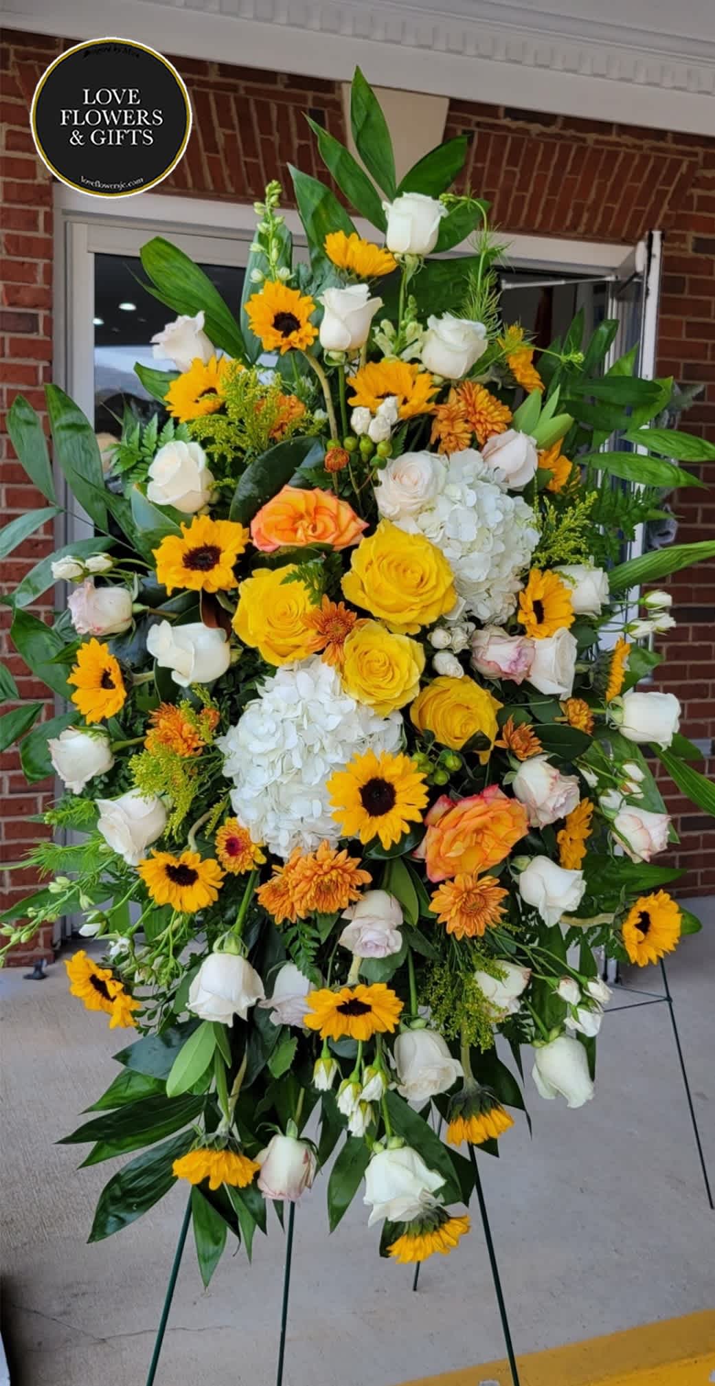 Bright Yellows (Standing Spray)  - Tall yellow and white standing spray on an easel for funeral/event delivery. The picture shows the approximate size.This one is made of yellow and white sunflower, roses, and hydrangeas and more.   If you like us to change or add certain colors, please write in "Florists Instructions" at Checkout.  (Please add the event/service time at checkout, we deliver before then). 