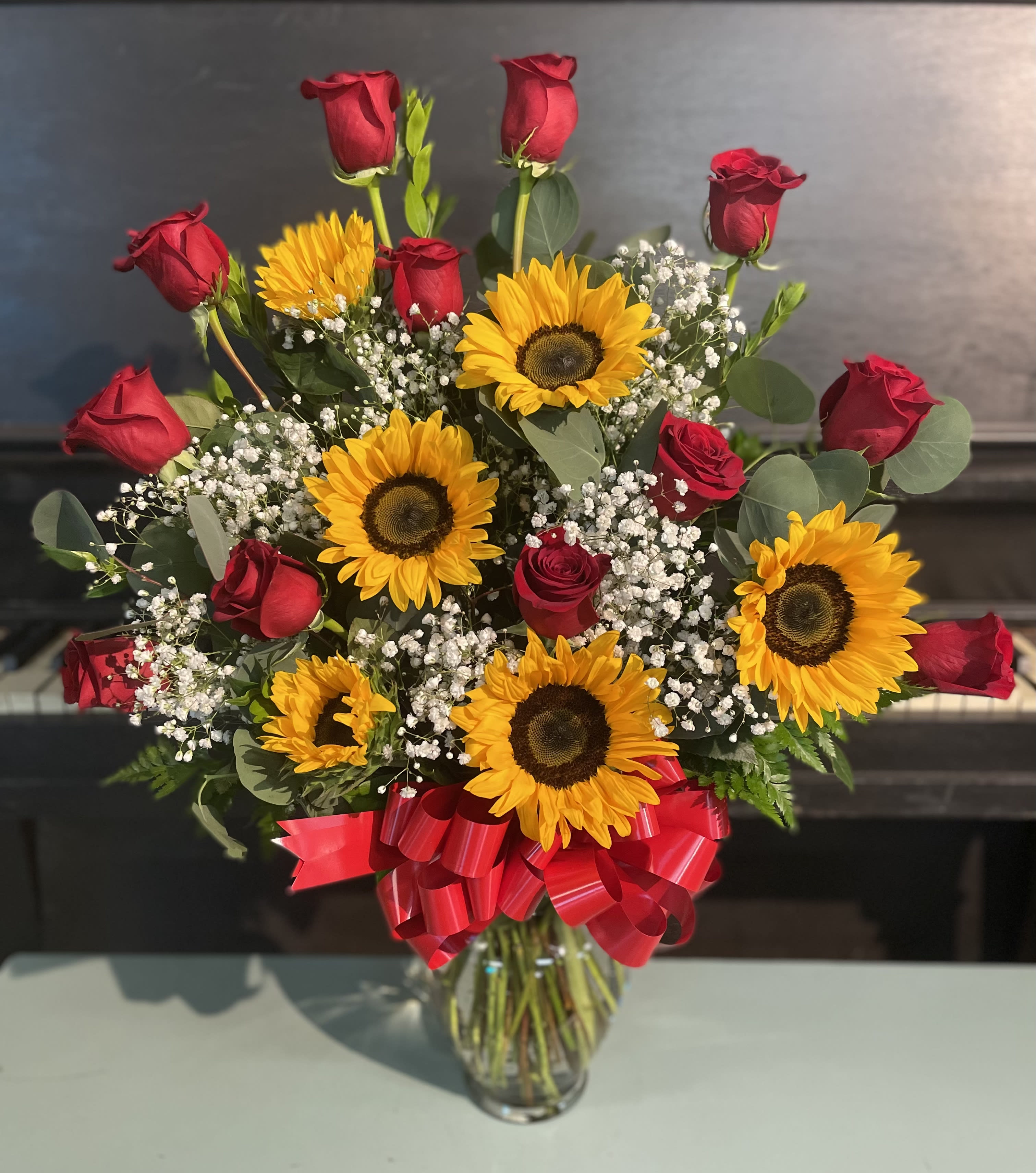 Sunshine and Love - A dozen of roses with sunflowers. Sure to bring a smile to anyone’s face. *sunflowers maybe be in different stages or different types*