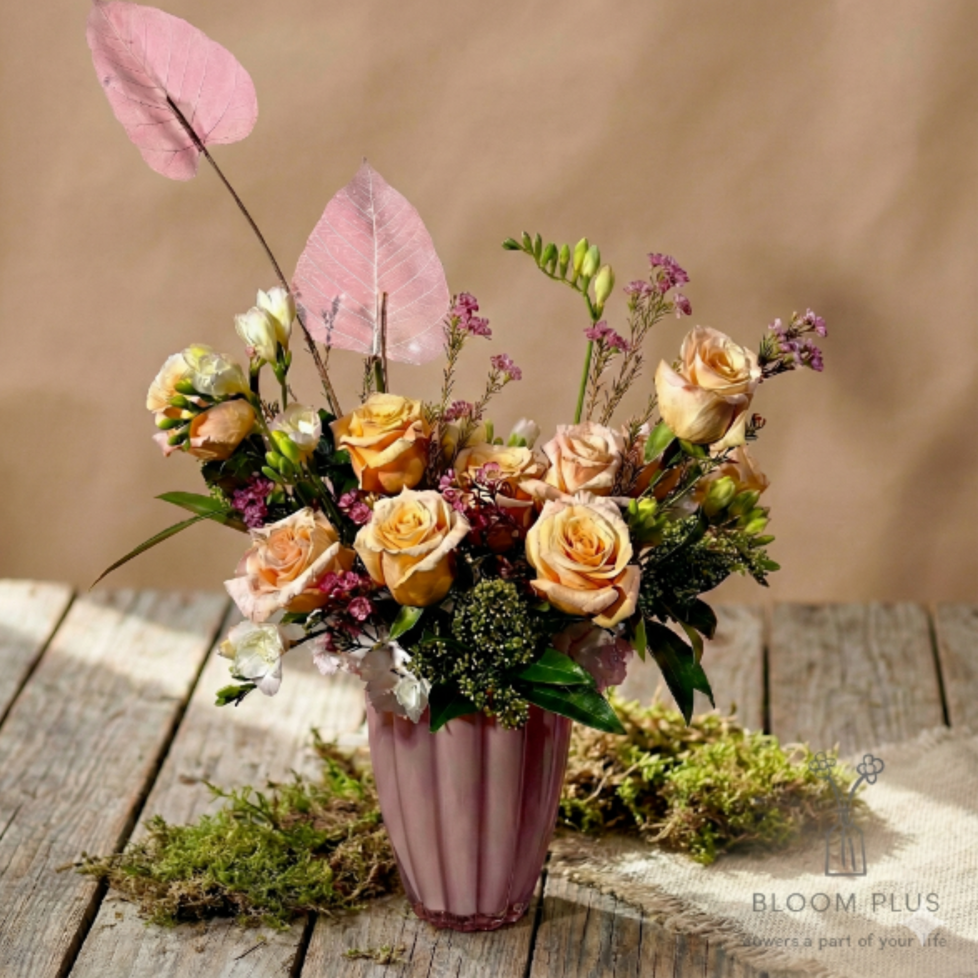 Peach Rose with Purple Wax Flower Bouquet (V1) - A mix of peach roses, fresh greens, and dainty blooms for a soft romantic look. Vase shown is for photo purposes. Final arrangement comes in a clear glass vase