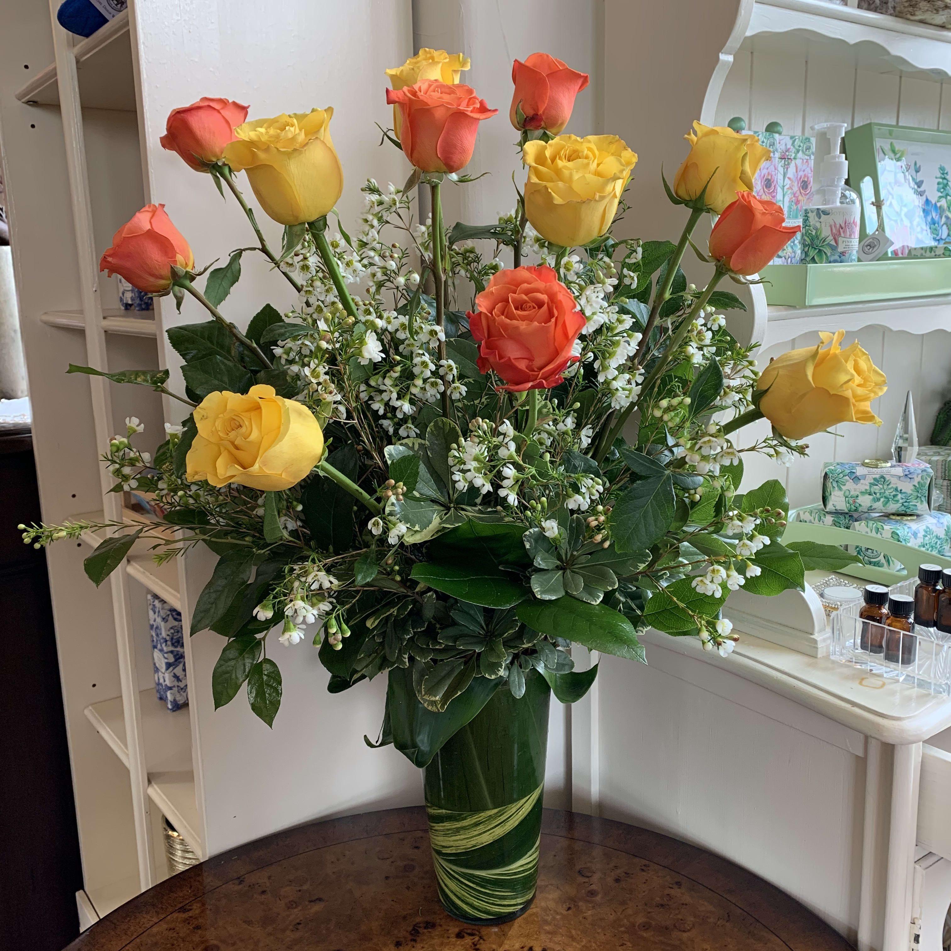 The Bright Spark Rose Bouquet - This spirited bouquet holds roses in bold hues -  Orange and bright yellow. Certain to be an attention-getter! These vivacious roses are arranged with premium greens and complimenting filler flowers in a leaflined glass vase. Regular in dozen roses, deluxe is 18 roses and premium is 2 dozen roses