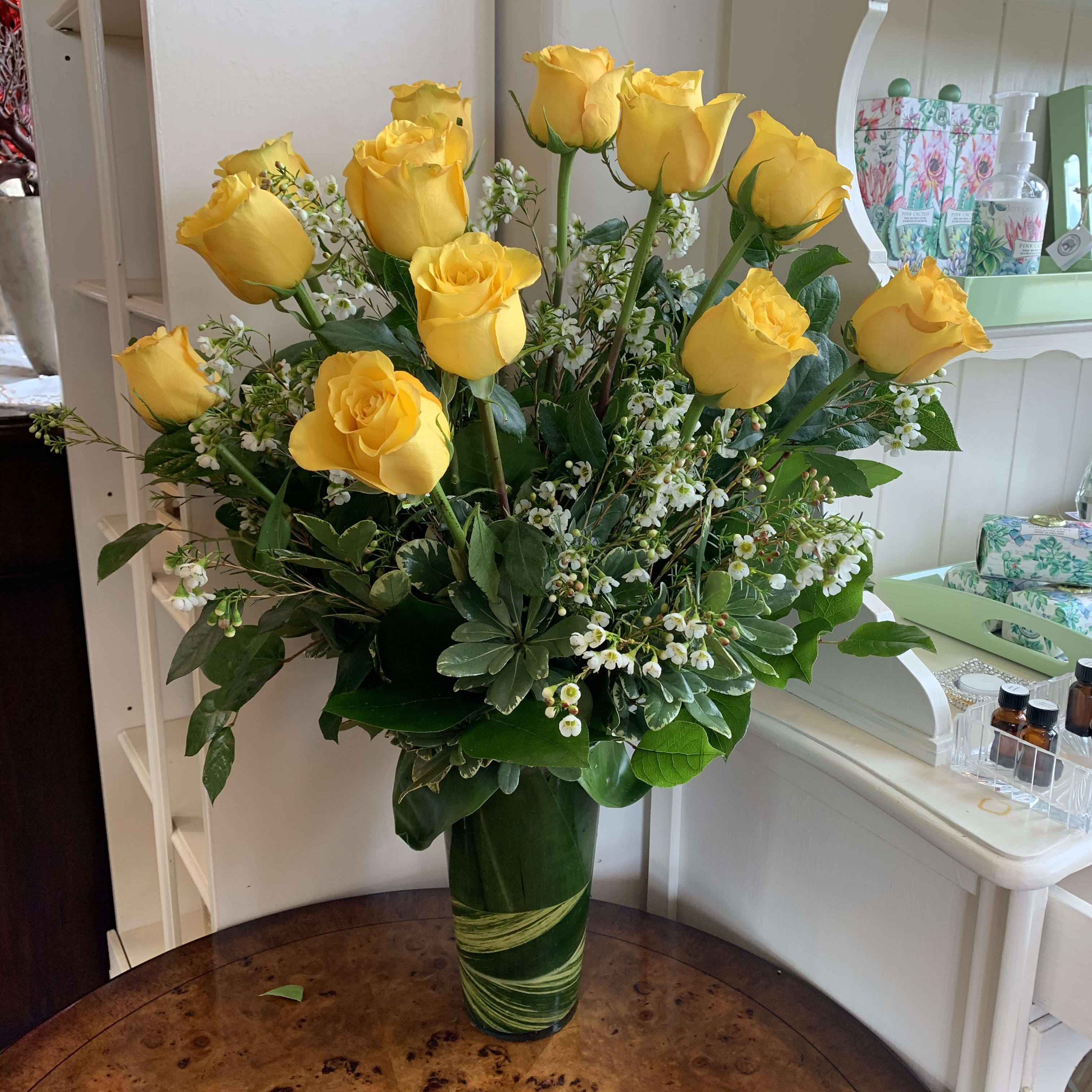 The Yellow Rose Bouquet - Premium longstem yellow roses arranged with complimenting filler flower and greens in a leaf lined glass vase.  Regular is a dozen roses, deluxe is 18 roses and premium is 2 dozen roses
