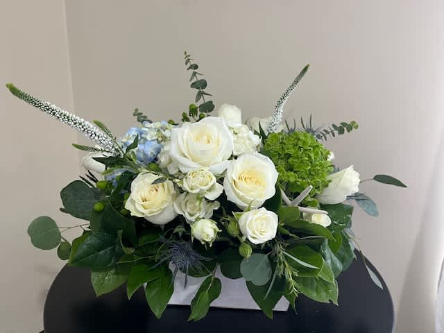 RELAX &amp; UNWIND - Medium Size Whitewash Wooden Box Arrangement Measuring: 3 1/2” Tall x 6 ¼” Square, Filled with Blue, Green and White Hydrangea, White Roses, White Clustered Roses, Blue Thistle, White Stock, Starfish Ornament, Premium Filler Flowers, Eucalyptus, Hard Ruscus and Lemonleaf.