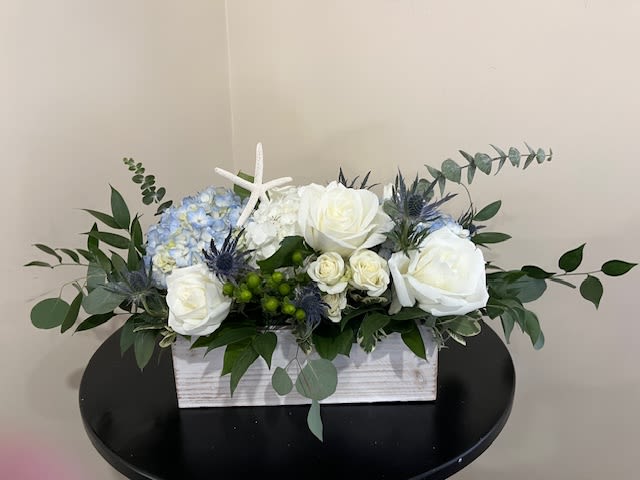Summer Vibes - Long and low arrangement in a shiplap box filled with Blue Hydrangea, White Roses, White Spray Roses, Thistle and Starfish Ornament