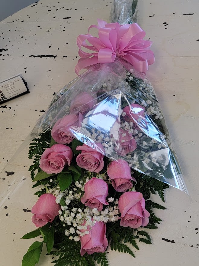 Dozen Pink Rose Presentation Bouquet - Lovely presentation bouquet of long stem pink roses arranged with filler flower and mixed greenery. Wrapped and tied with a matching bow. Varieties of Pink Roses vary. Usually light to medium shade of pink unless requesting bright pink. Standard, 12 roses Deluxe, 18 roses Premium, 24 roses