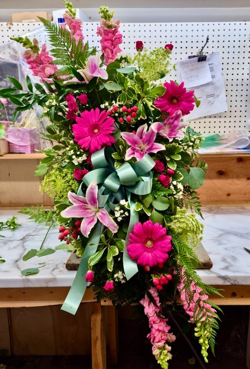Forever Feelings by Lotherington's -  This gorgeous standing spray in beautiful pink hues displays luxurious style when Lilies, Gerbera daisies and Roses come together with greenery to create a beautiful salute.