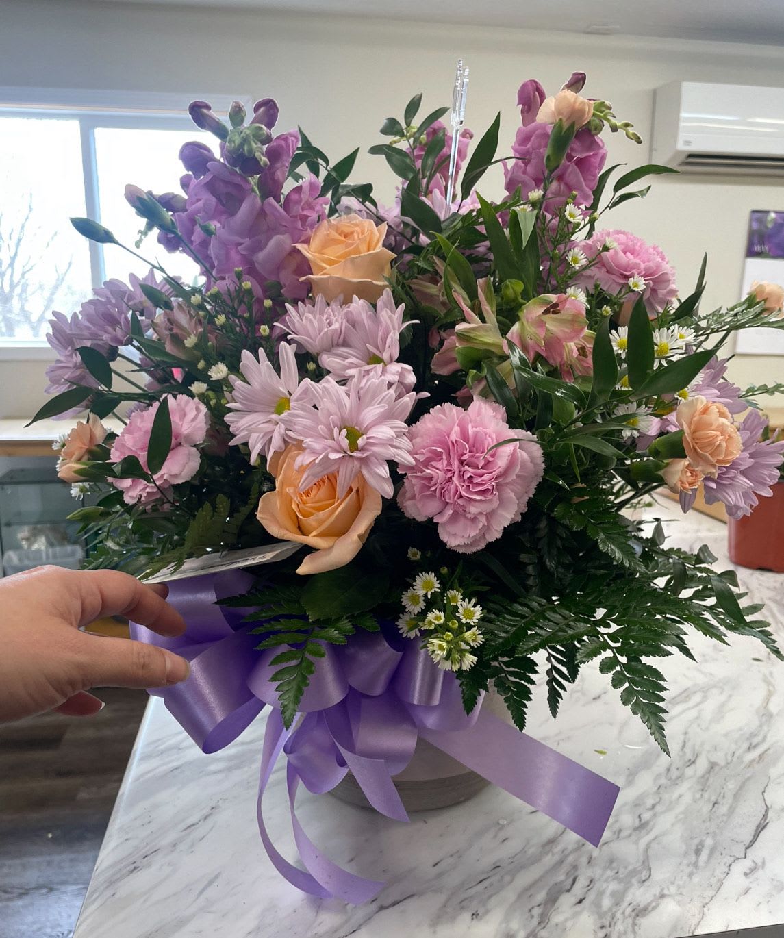 Royalty by Lotherington's - This beautiful arrangement in hues of soft pink, lavender and a touch of orange, is perfect for any event ranging from a housewarming gift for a friend, to a birthday surprise! Send it to somebody who deserves to be treated royally.  Approximate Dimensions: 10"D x 10"H