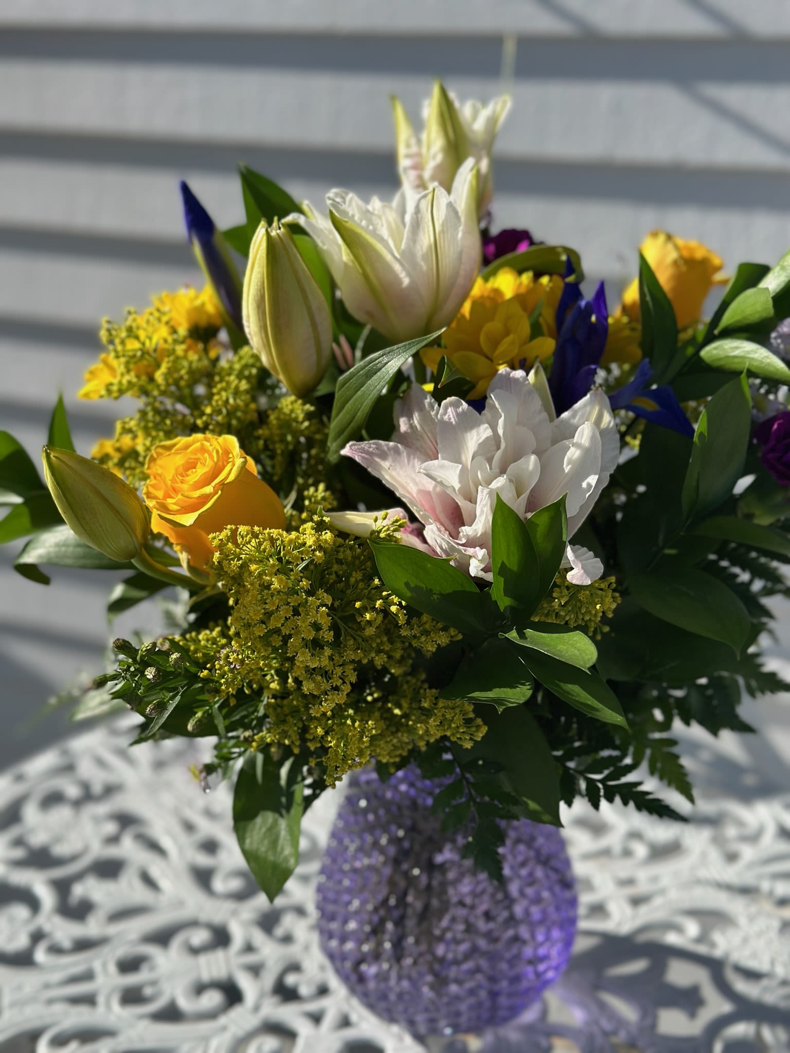 Purple Passion Bouquet - Pink Lilies, Yellow roses daisies, iris, purple carnations and solidago arranged in a purple glass etched vase