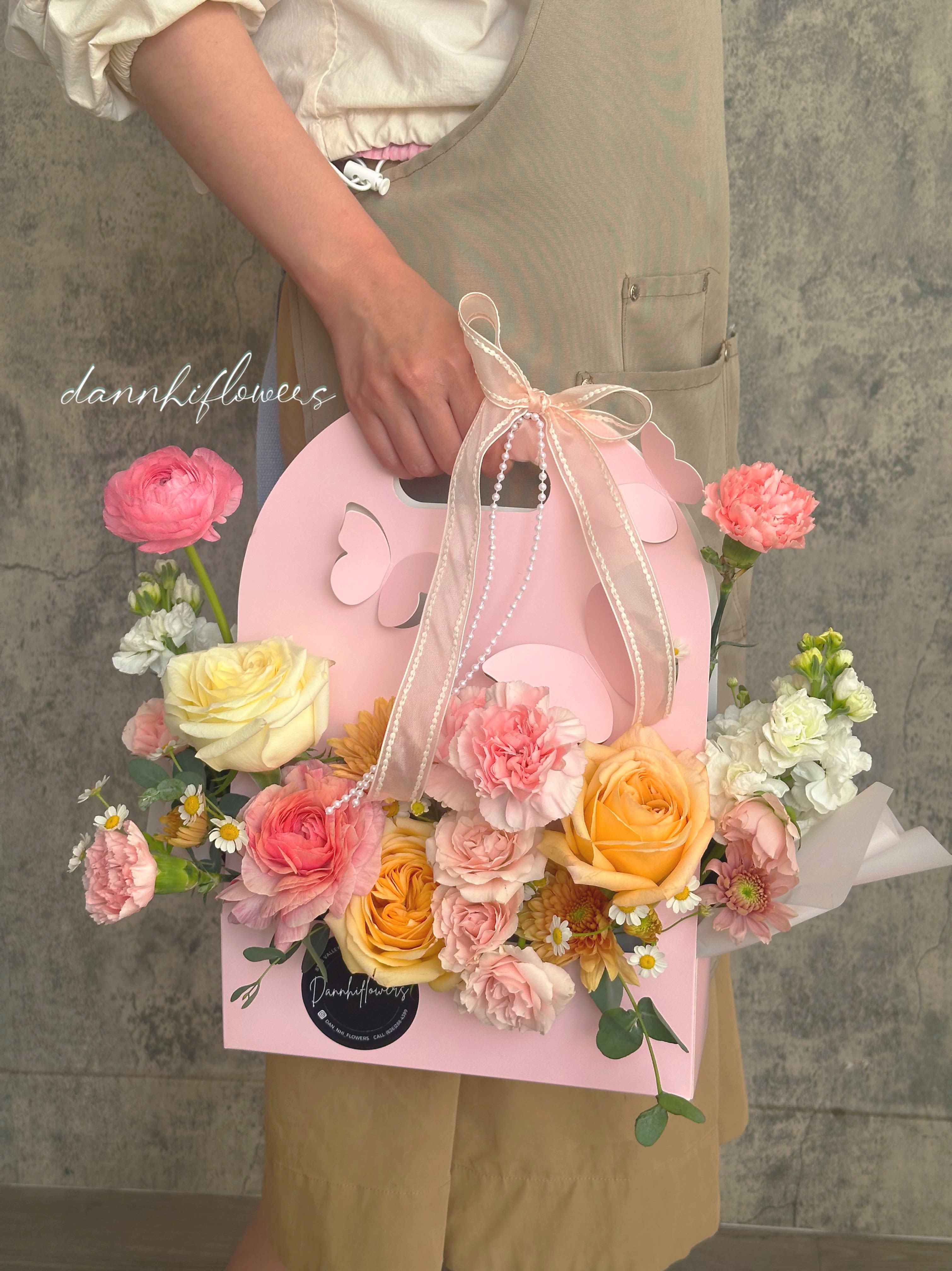 Butterfly kisses. - Delicate blooms in soft pastel tones, nestled in a charming butterfly pink bag, a sweet and graceful gesture to celebrate Mom’s love, beauty, and gentle spirit.
