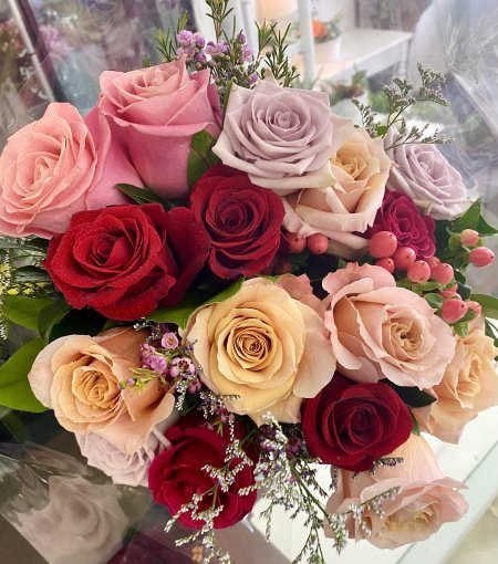 Dozen Assorted Roses Wrapped - Twelve gorgeous roses in assorted colours designed with your choice of basic greenery or fancy filler wrapped in tissue and cellophane.
