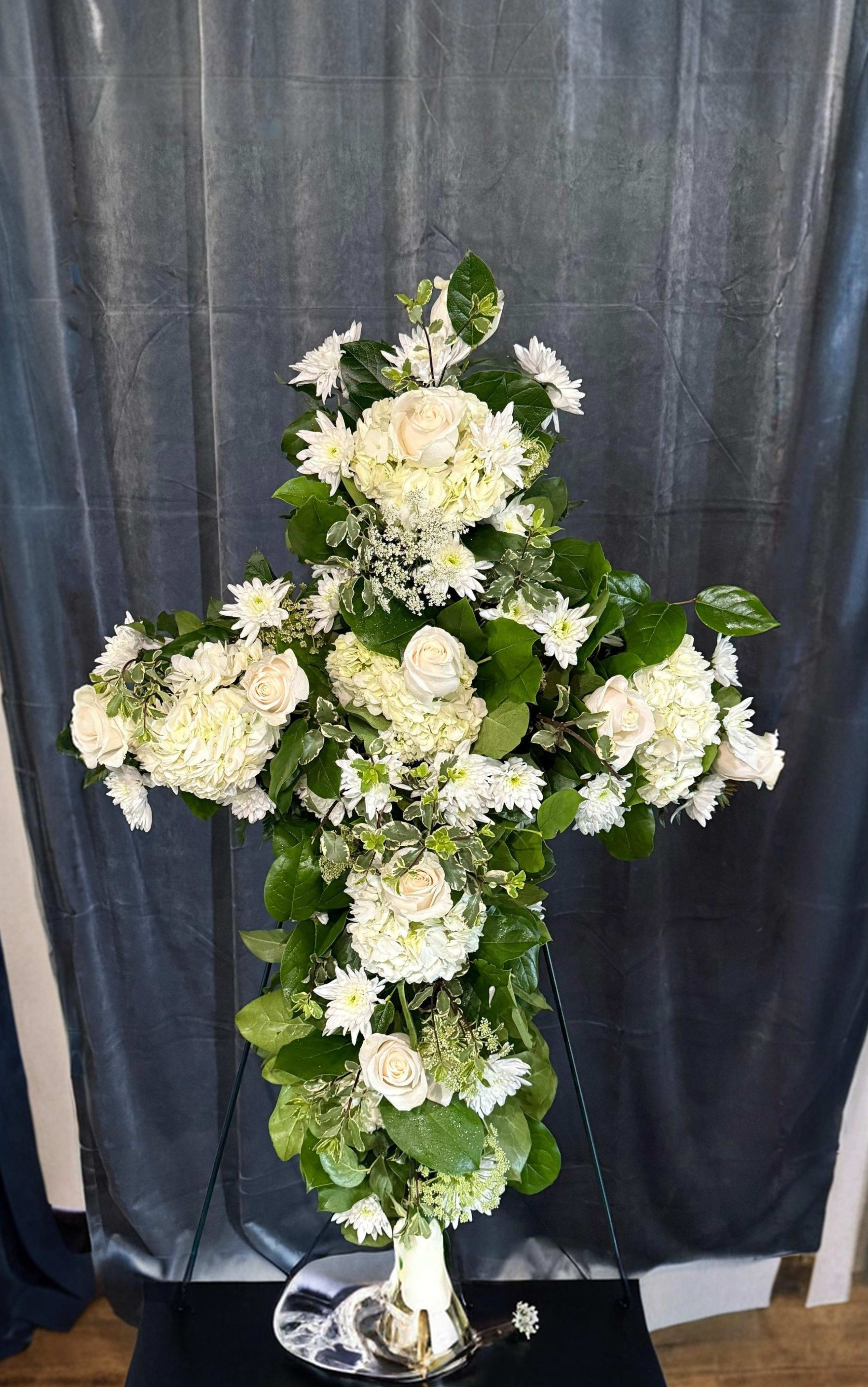White Cross Spray  - White flowers with greens cross spray   Please note: Standing sprays require advance scheduling. The earliest delivery date shown at checkout is not guaranteed and may be adjusted if needed.  Funeral standing sprays require a two-day lead time. Orders placed today will be eligible for delivery beginning two days from the order date.  Please call shop to confirm (760) 996-2120