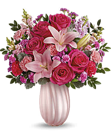 Rosy Swirls Bouquet - Capture Mom's heart with our pearlescent Teleflora's Rosy Swirls vase, radiating elegance and charm, paired with a bouquet of pink roses and lavender blooms, a delightful Mother's Day surprise she'll cherish. Create magic for Mom with Teleflora's Rosy Swirls vase, complemented by a bouquet of hot pink roses, pink asiatic lilies, light pink and hot pink carnations, miniature carnations, pink snapdragons, light pink stock, raspberry sinuata statice, huckleberry, and dusty miller, a radiant Mother's Day surprise she'll cherish. Orientation: All-Around