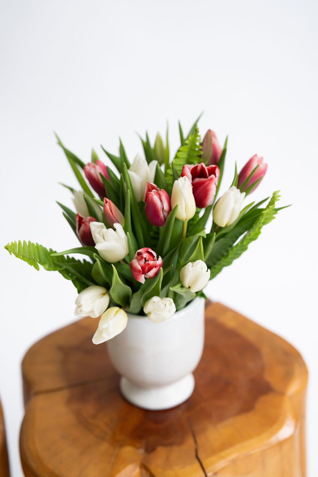 Topaz - Simple, elegant, and stunning -- the tulip is considered by many to be the most beloved of all blooms.  If you're looking to show your affection (and maybe show off just a little), look no further than this abundance of floral perfection housed in a classy modern white ceramic compote.  These tulips are grown and harvested in Virginia.  Color of tulip may vary; please let us know if you have a preference in the special instructions.  The standard-sized arrangement contains 20 stems of tulips and measures approximately 12" tall by 10" wide. The deluxe-sized arrangement contains 30 stems of tulips and measures approximately 14" tall by 12" wide.